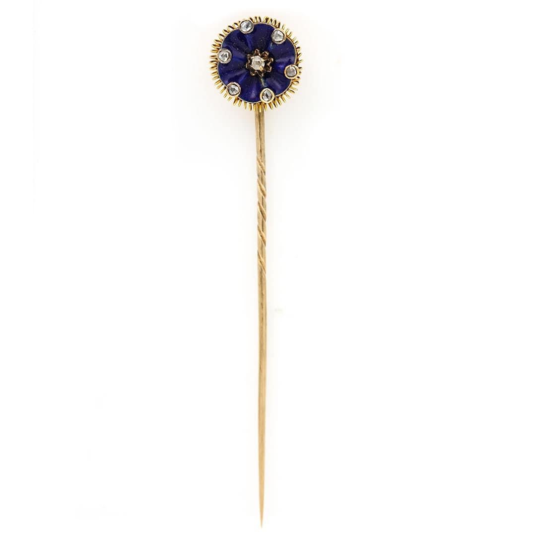 A smart and sophisticated Victorian 15ct gold dark blue enamel and rose cut diamond floral motif stick pin dating from circa 1890. The head of the stick pin is designed with a central set diamond from which a ruffled, undulating ribbon radiates
