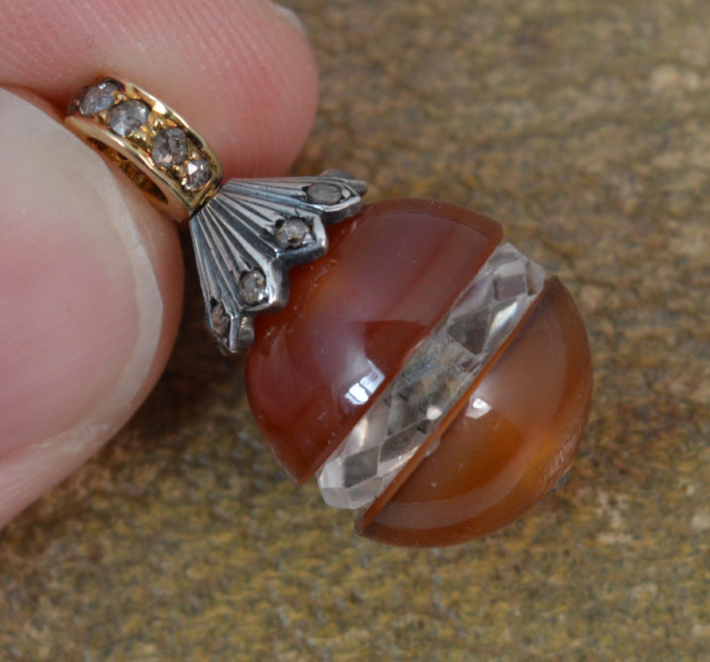 A stunning Victorian period egg shaped drop pendant.
Modelled with a yellow gold bale encrusted with natural rose cut diamonds. Below a white metal setting set with rose cut diamonds. Below hangs two pieces of red banded agate with a carved rock