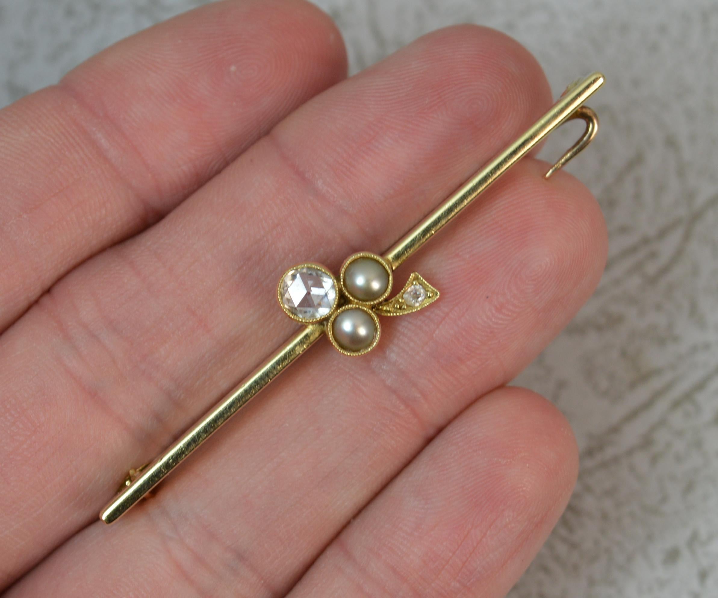 A stunning quality bar brooch.
15 carat yellow gold example.
Designed with a three leaf clover design comprising of large rose cut diamond, spreads 0.5ct with two pearls to each side and a further old cut diamond below. All fine grain bezel