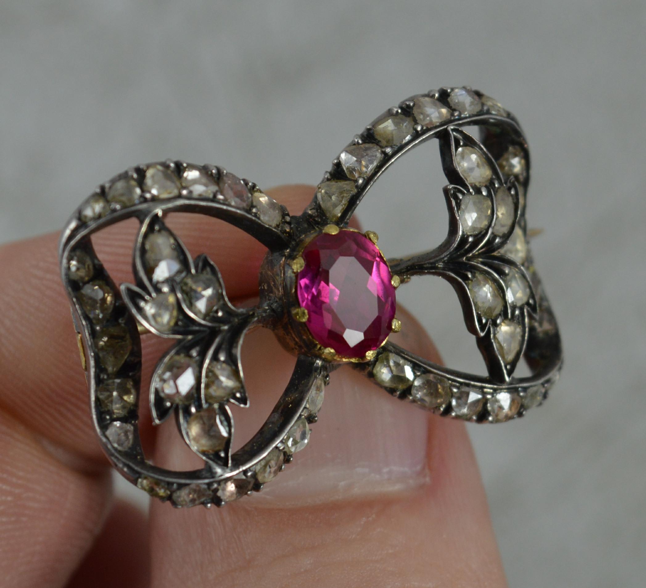 A stunning mid Victorian era brooch.
Solid 15 carat rose gold example and silver head setting.
Oval shaped 7.7mm x 6.0mm synthetic pinky red coloured ruby to centre.
Surrounding are 46 natural rose cut diamonds.

CONDITION ; Very good for age.