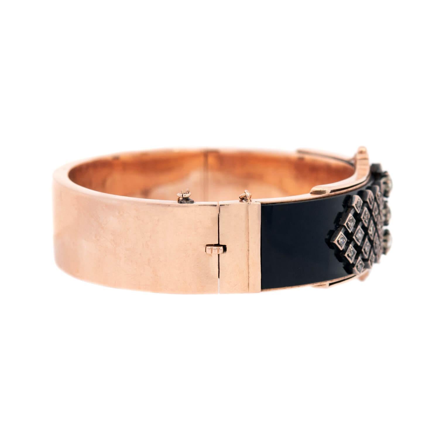 A gorgeous bangle bracelet from the Victorian (ca1880) era! Crafted in 15k rose gold, the surface of the bracelet features a rectangular-shaped onyx plague. The onyx is encrusted with three central old mine cut diamonds, which run vertically down
