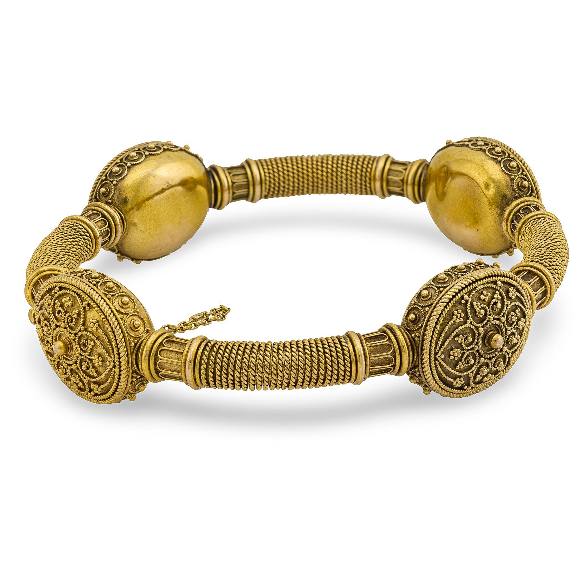 A stunning Etruscan-style bangle from the Victorian (ca1880s) era! Crafted in 15k yellow gold, this bracelet features four oval-shaped panels, which are decorated with highly-intricate Etruscan detailing! The face of each panel features blooming