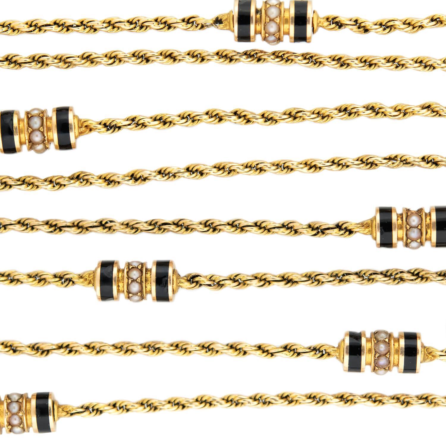 A beautiful gold watch chain from the Victorian (ca1880) era! Crafted in 15k gold, this extra long rope chain features six interspersed barrel shaped links. The links are centrally decorated with small bead set pearls, which create a wonderful