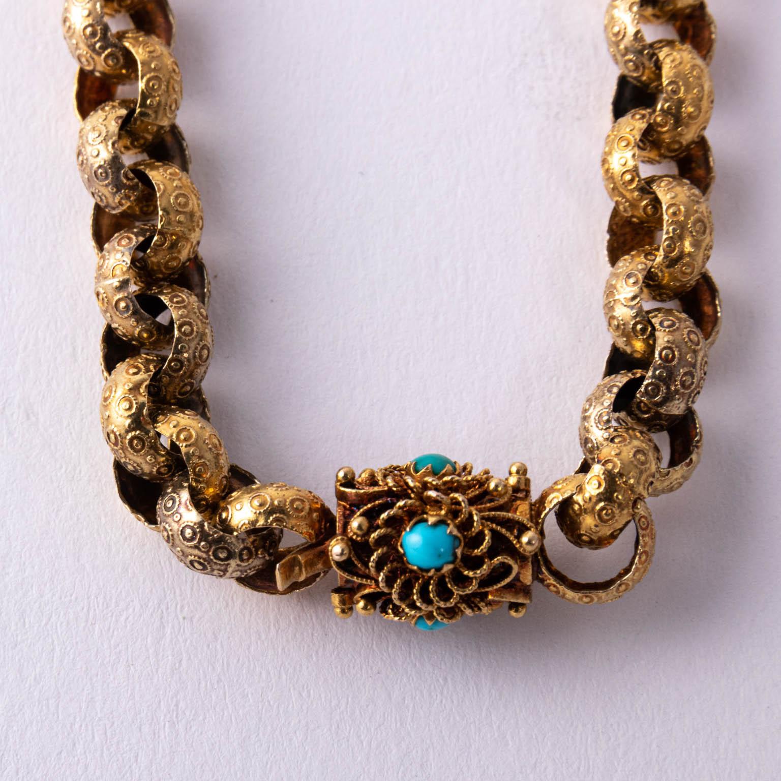 Circa 1870s Victorian necklace from England. Tested to be at least 14 karat to 15 karat. The necklace has large Rollo links of 7.5 mm. Each link is decorated with circles. It finishes with an Etruscan revival style filigree clasp with tiny turquoise