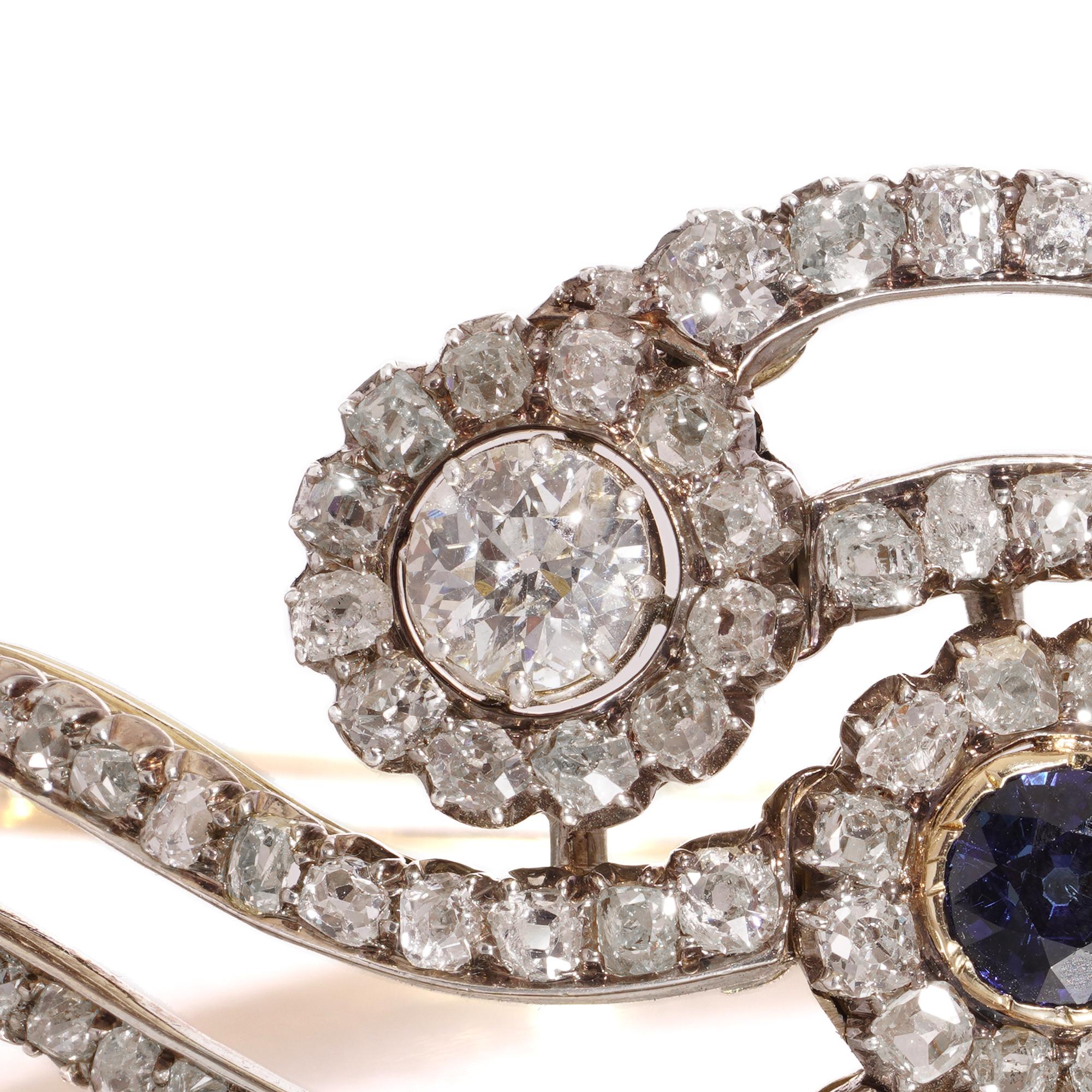 Victorian 15kt Gold Diamond & Sapphire Bangle – 4.5ct Total Diamond Weight
Circa 1880–1900  Approx. 4.5ct Total Diamond Weight

A beautifully handcrafted Victorian bangle in 15ct gold with silver-topped settings, featuring a flowing, asymmetrical