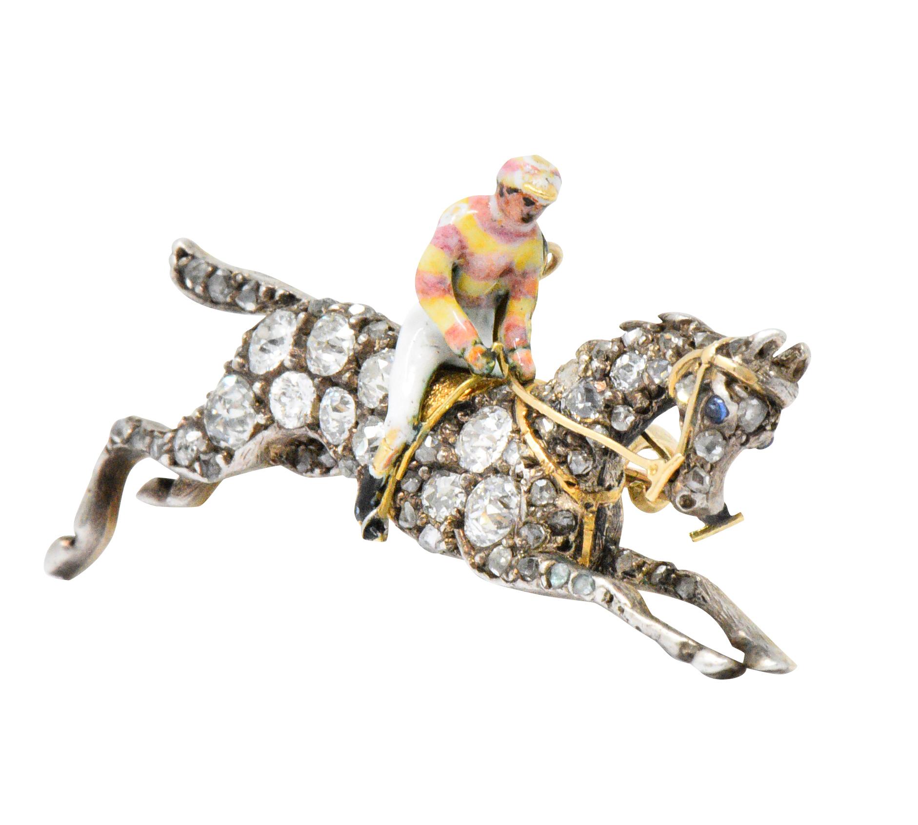 Pendant brooch designed as an enameled jockey figure riding a galloping horse

Set throughout by rose cut diamonds weighing approximately 1.65 carats total

Pastel enamel 