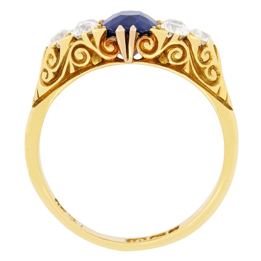 This stunning Victorian ring centres around a 1.70 carat, natural and unheated, oval cut sapphire. The deep blue sapphire is flanked by an additional three old cut diamonds on either side. These diamonds total 0.90 carat and have been estimated at F