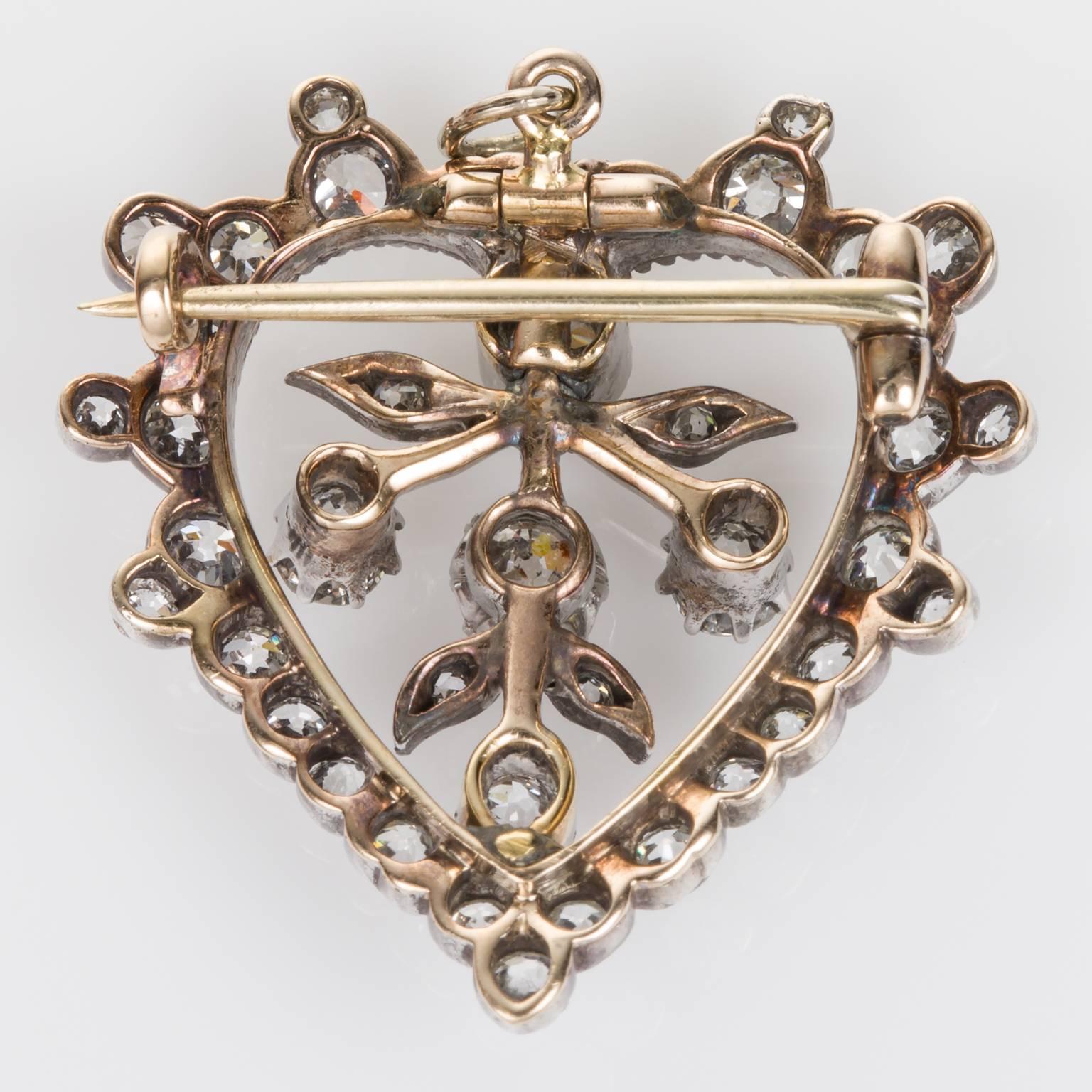 Old world charm meets modern day elegance. A beautiful Victorian silver over gold heart-shaped diamond pendant or brooch, set with 39 old European cut diamonds weighing approximately 1.75cts. It has multiple looks and can become a 'go-to' piece in