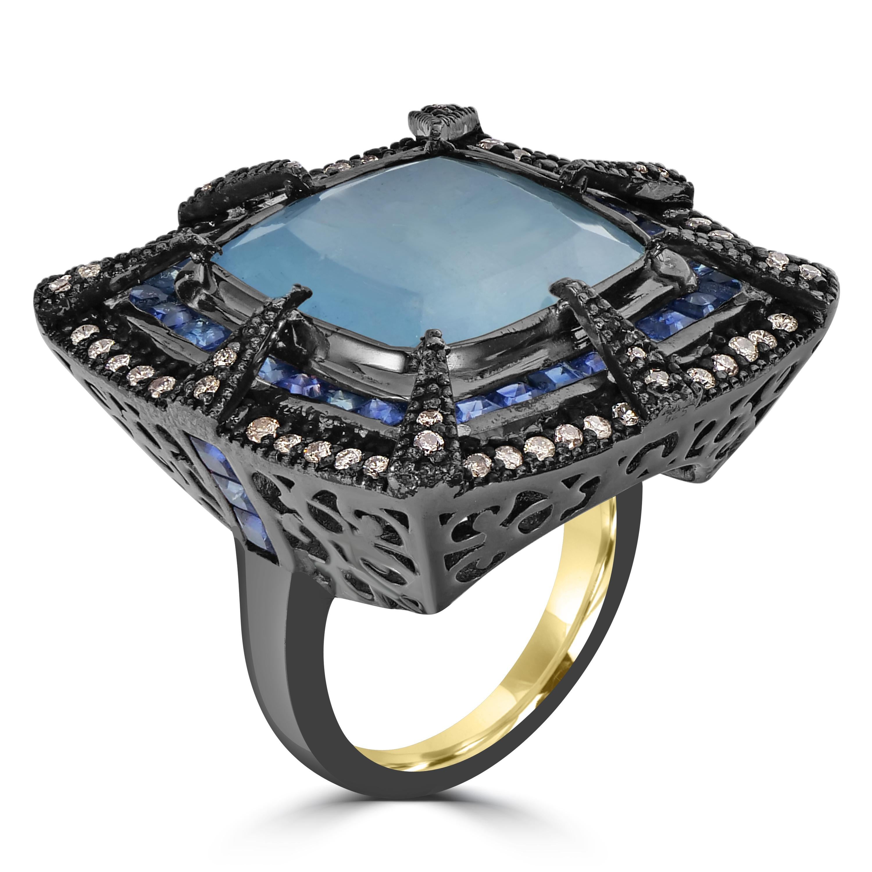Indulge in the regal charm of the Victorian 17.5 Cttw. Aquamarine, Sapphire, and Diamond Cocktail Ring — a masterpiece that fuses classic design with modern allure. At its heart sits a cushion-cut aquamarine, a majestic 13.5 carats, securely