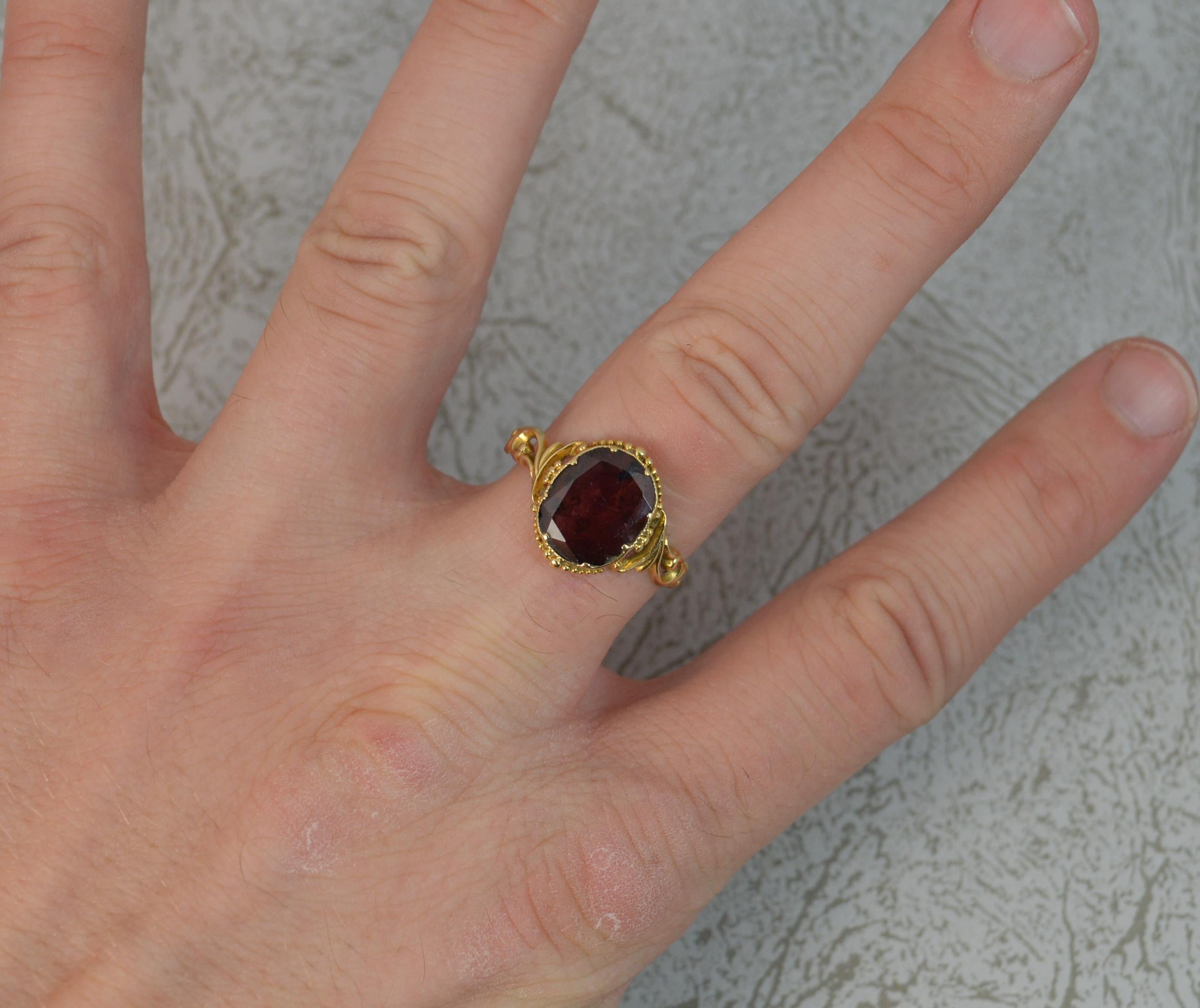 A superb early Victorian period ring, c1840/50.
Solid 18 carat yellow gold example.
Designed with a single oval shaped, flat cut garnet in closed foiled back setting with fine bead design surrounding.
9mm x 11mm approx.

CONDITION ; Very good. Well