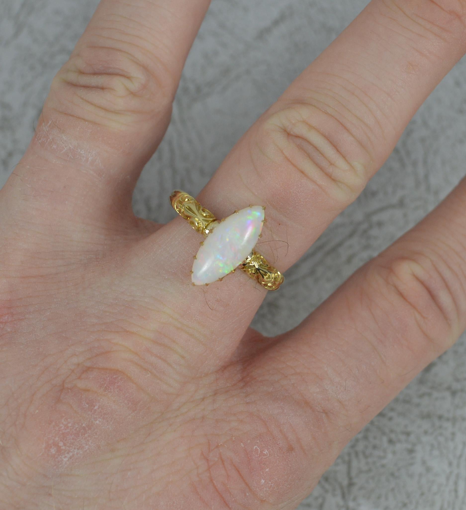A stunning Opal solitaire ring from c1890.
Solid 18 carat yellow gold shank with scroll pattern to shoulders.
Designed with a natural, marquise shaped opal in a multi claw setting.
6mm x 14.5mm opal. Natural. Good display of colour.

CONDITION ;