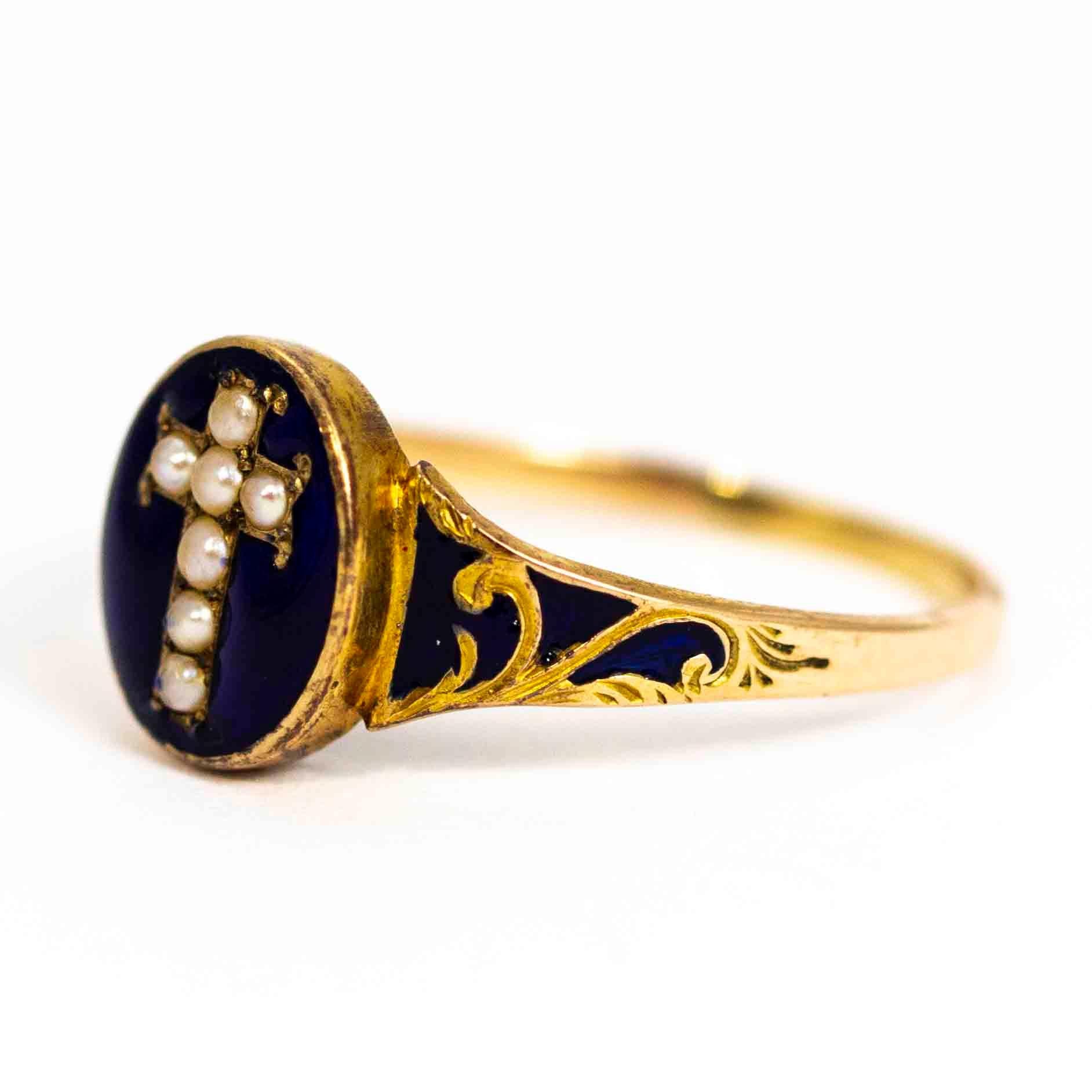 An exquisite antique Victorian mourning ring. Fronted with a superb pearl cross surrounded by glossy royal blue enamel. The oval panel is backed with a glazed locket. The elegant shoulders are set with ornate gold detailing and more beautiful