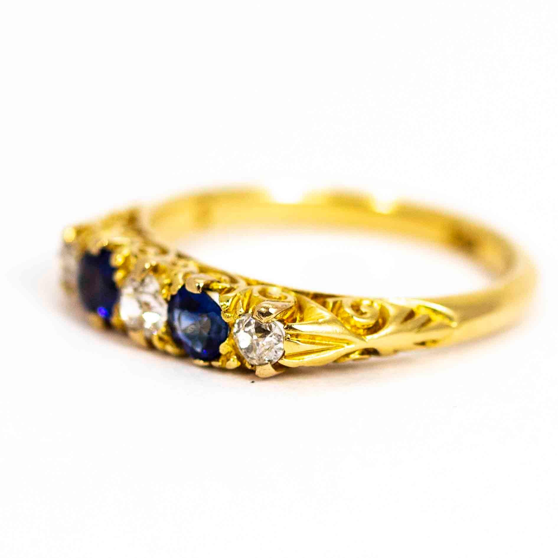 A stunning antique late Victorian five-stone ring set with blue sapphires and white old European cut diamonds. The central diamond measures approximately 15 points, the diamonds at the ends measure approximately 10 points each. Total diamond weight