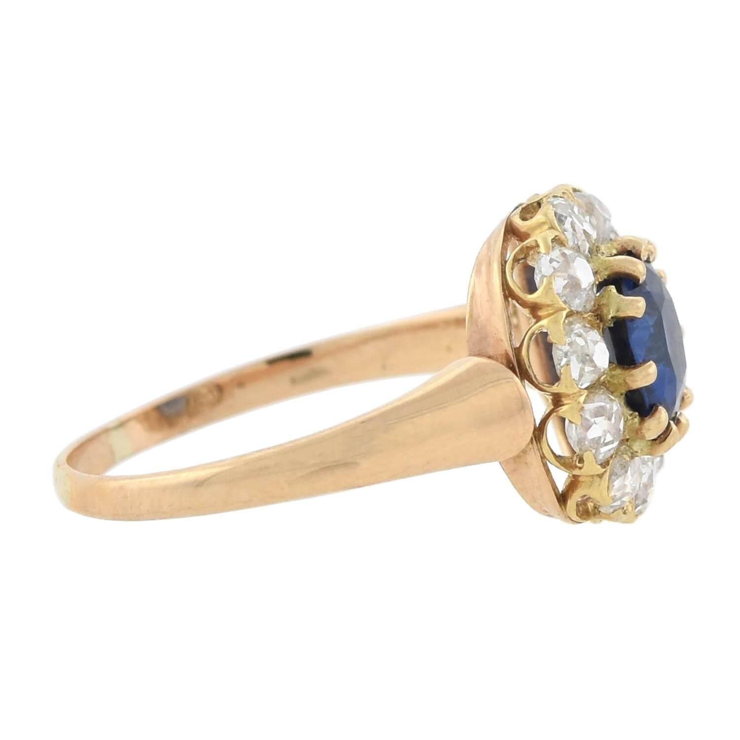 A gorgeous sapphire and diamond cluster ring from the late Victorian (ca1880) era! This beautiful 18kt gold ring features a 1.00ct natural ceylon sapphire framed at the center of a sparkling diamond border. The vivid, no-heat sapphire is prong set