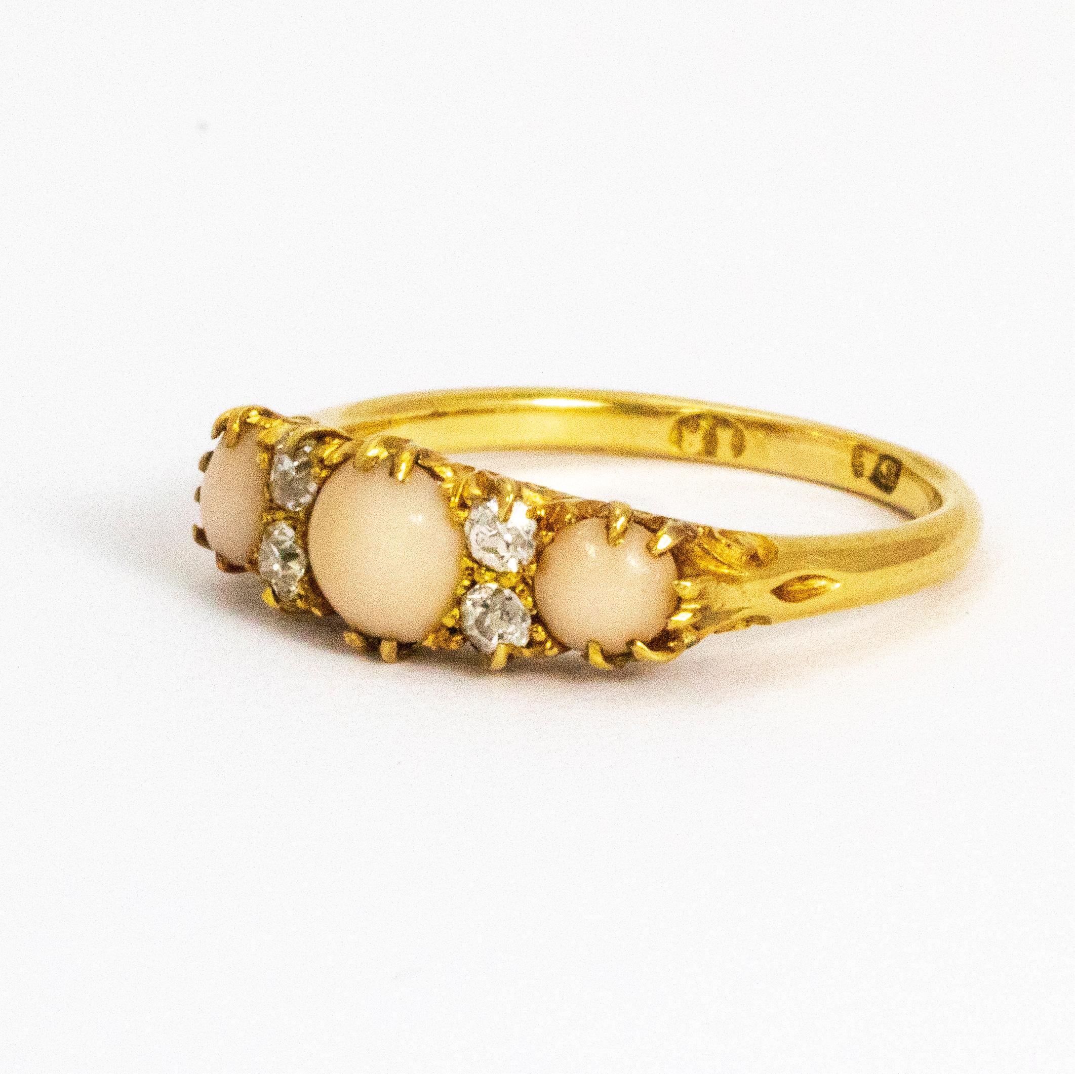A superb victorian three-stone ring set with three beautiful graduated pale pink circular coral cabochons. Each of the cabochons is divided by a pair of bright old European cut white diamonds. Modelled in 18 karat yellow gold.

Ring Size: O or 7.5