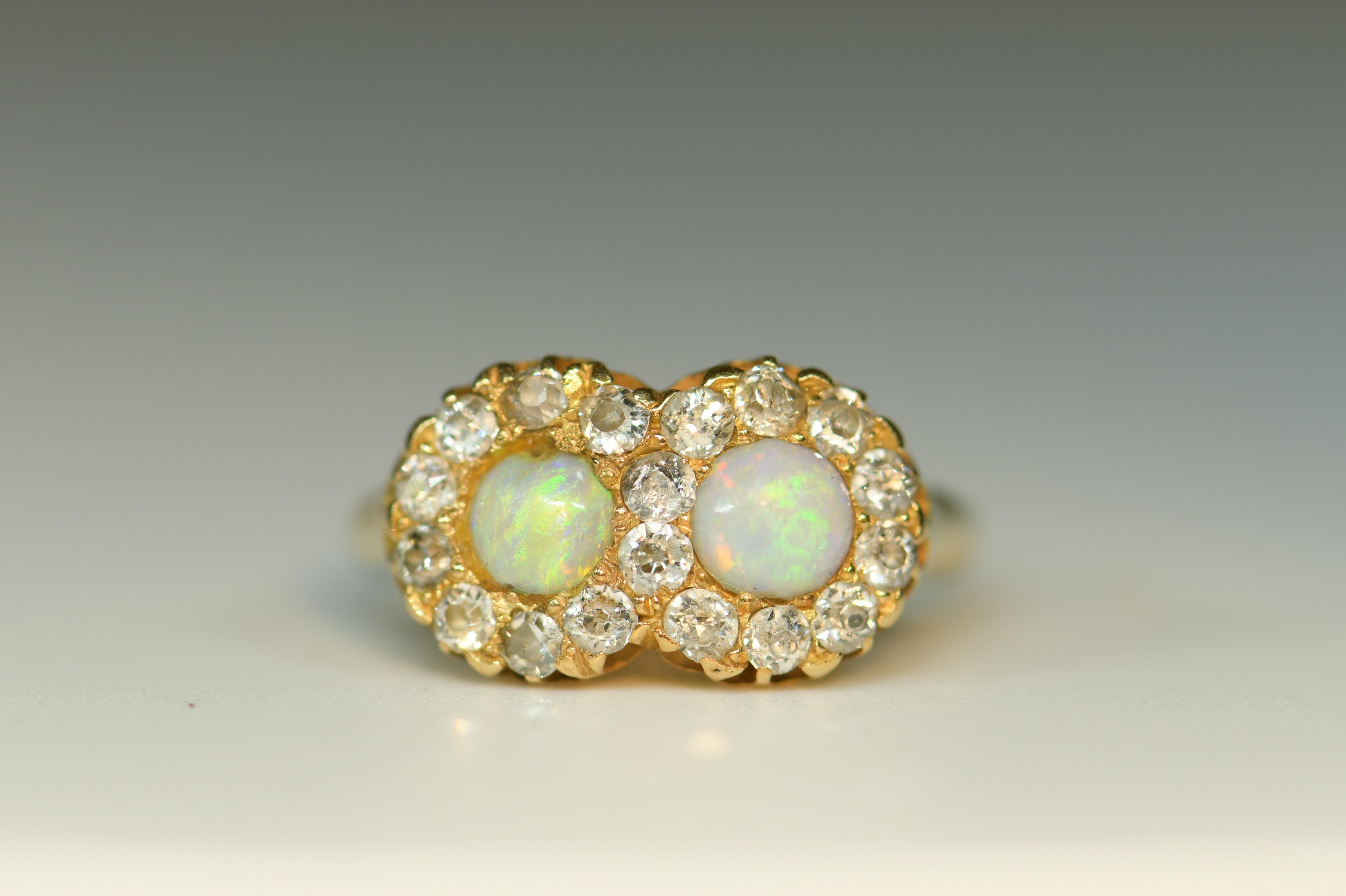 This is a Victorian-era 1880 beautiful double opal ring. Crafted in 18 karat gold. The two opals of approx 4mm are surrounded with old cut diamonds to an estimated approx combined total of 0.45cts.

Opal is a delicate stone with fine but vibrant
