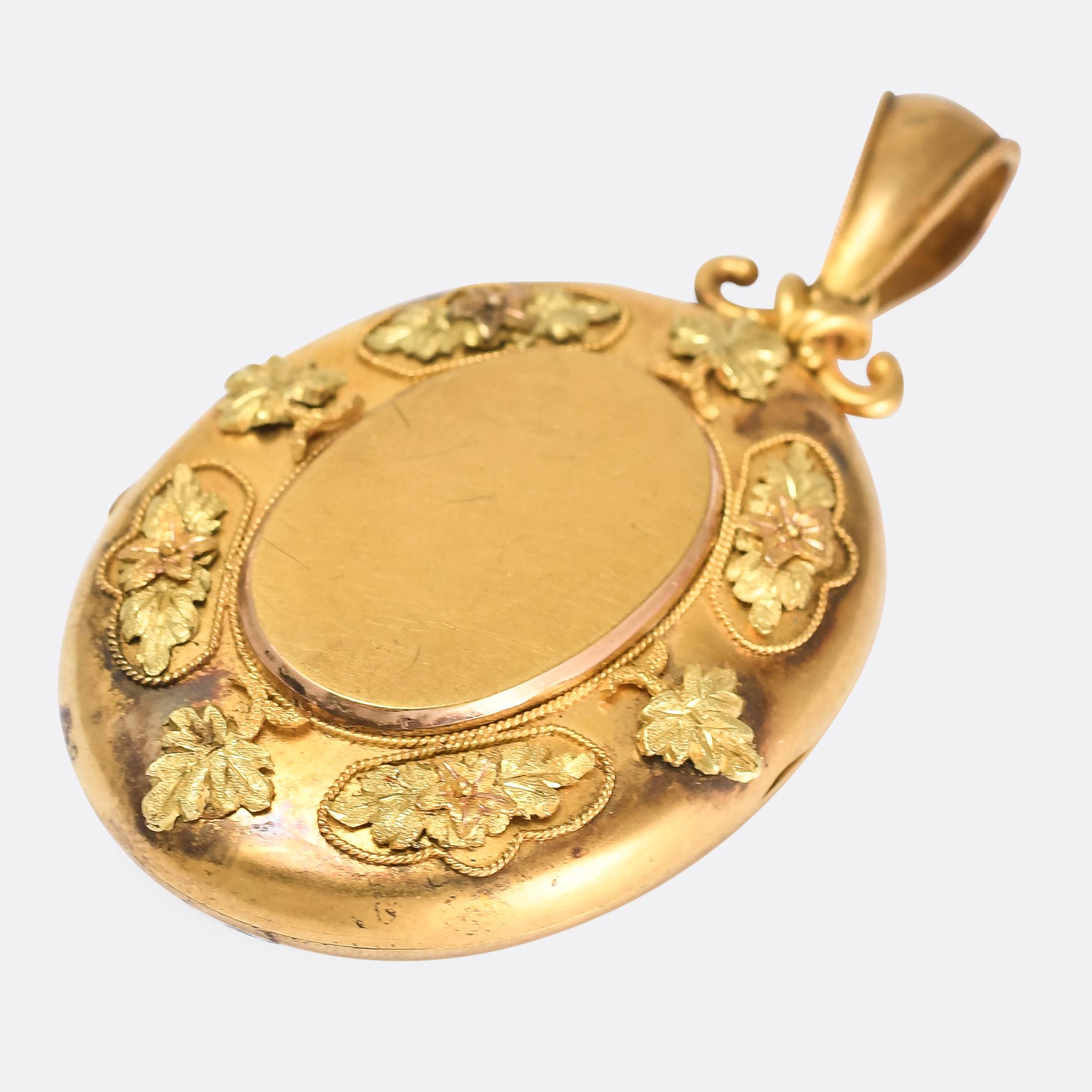This gorgeous antique oval locket dates from the mid Victorian period, circa 1870. It's modelled in three-tone 18 karat gold, and features applied grape leaves and floral decoration, as well as ropework borders. Complete with the original bail, it's