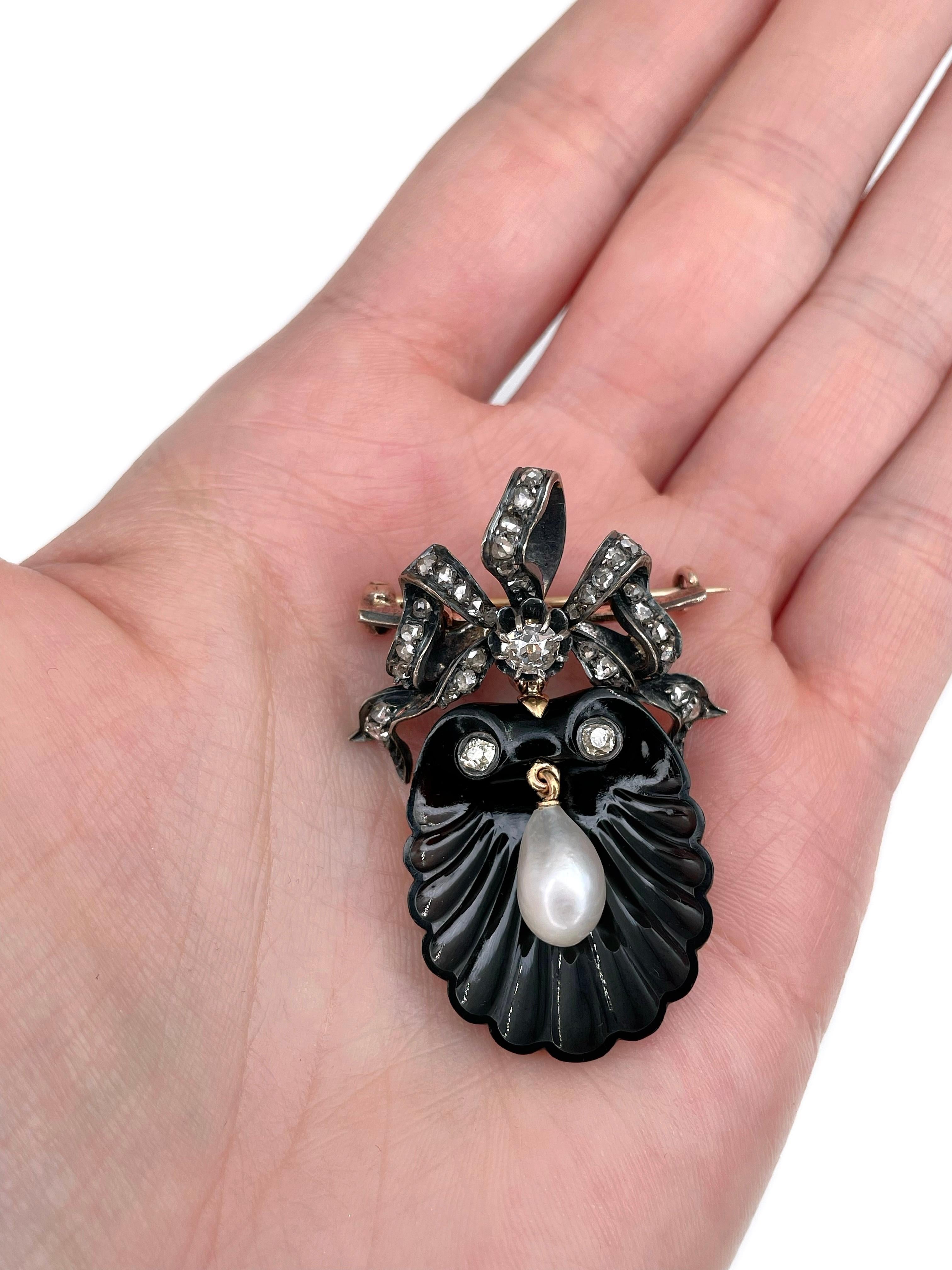 This is a delicate Victorian bow shell shape pin brooch crafted in 18K gold. Circa 1890.

The piece features a carved shell shape agate. There is a pearl in the centre. The bow is adorned with old mine cut and rose cut diamonds.

Has a C clasp.