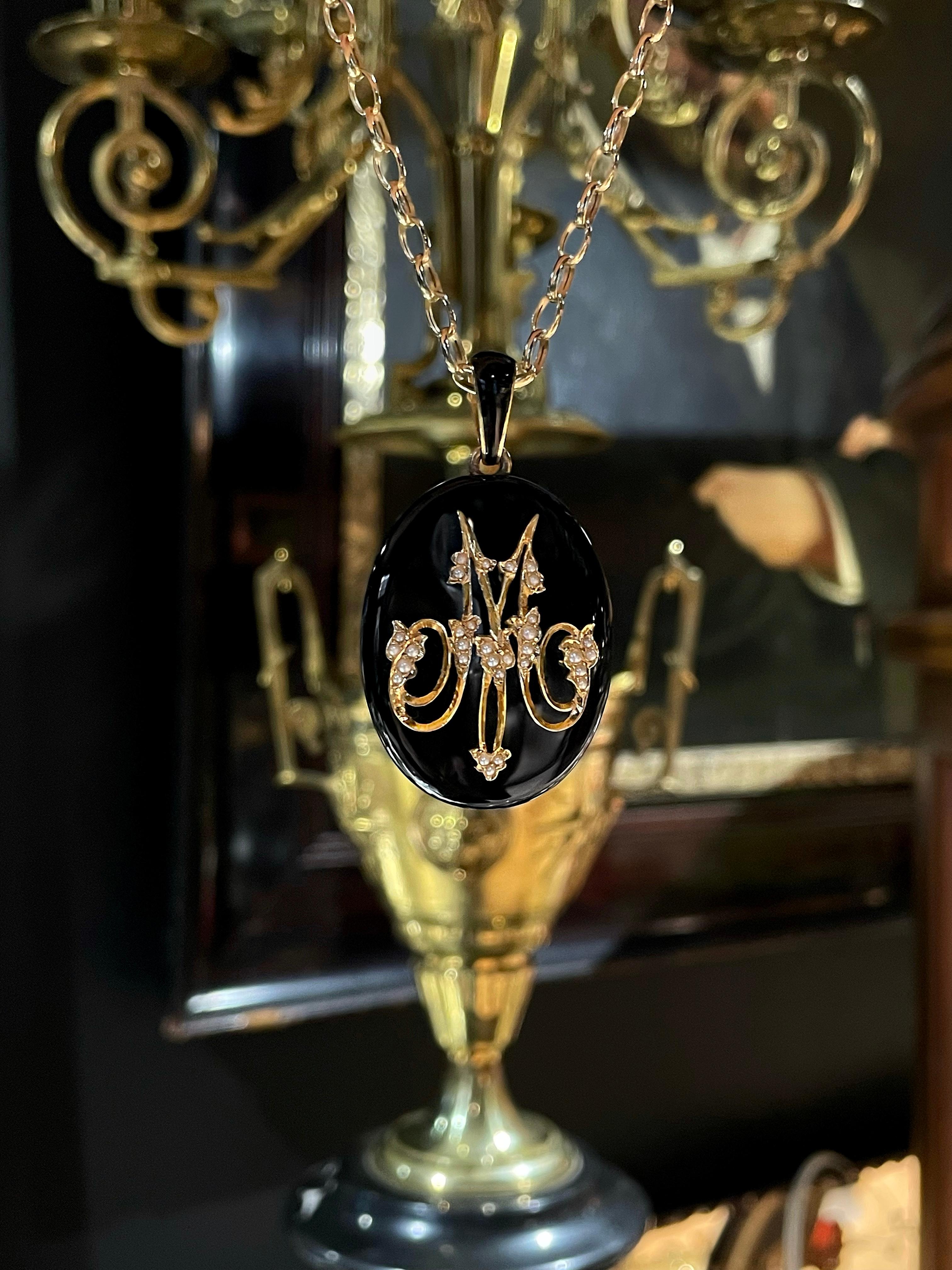 This is an antique Napoleon 3rd style oval locket pendant crafted in 18K gold. Circa 1870. The piece is made of onyx. The letter M is beautifully set with seed pearls. It has a space under a glass for the picture on the back side. 

Weight: