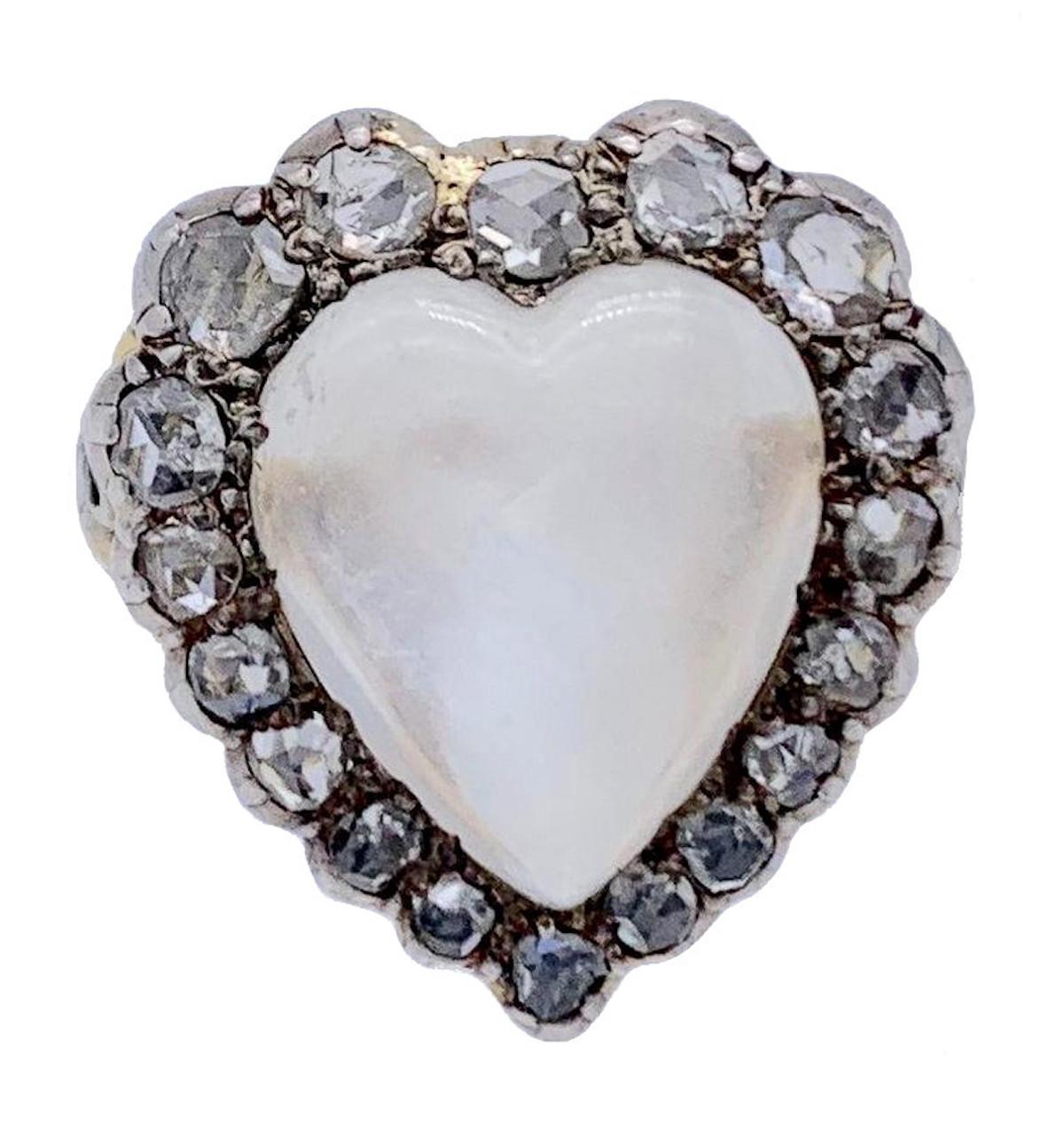 A moonstone cabochon in the shape of a heart is surrounded by diamonds set in silver and mounted on a beautifully engraved golden shank. The inside of the ring rail has British hallmarks for London 18kt, the head of Victoria looking to the left, the