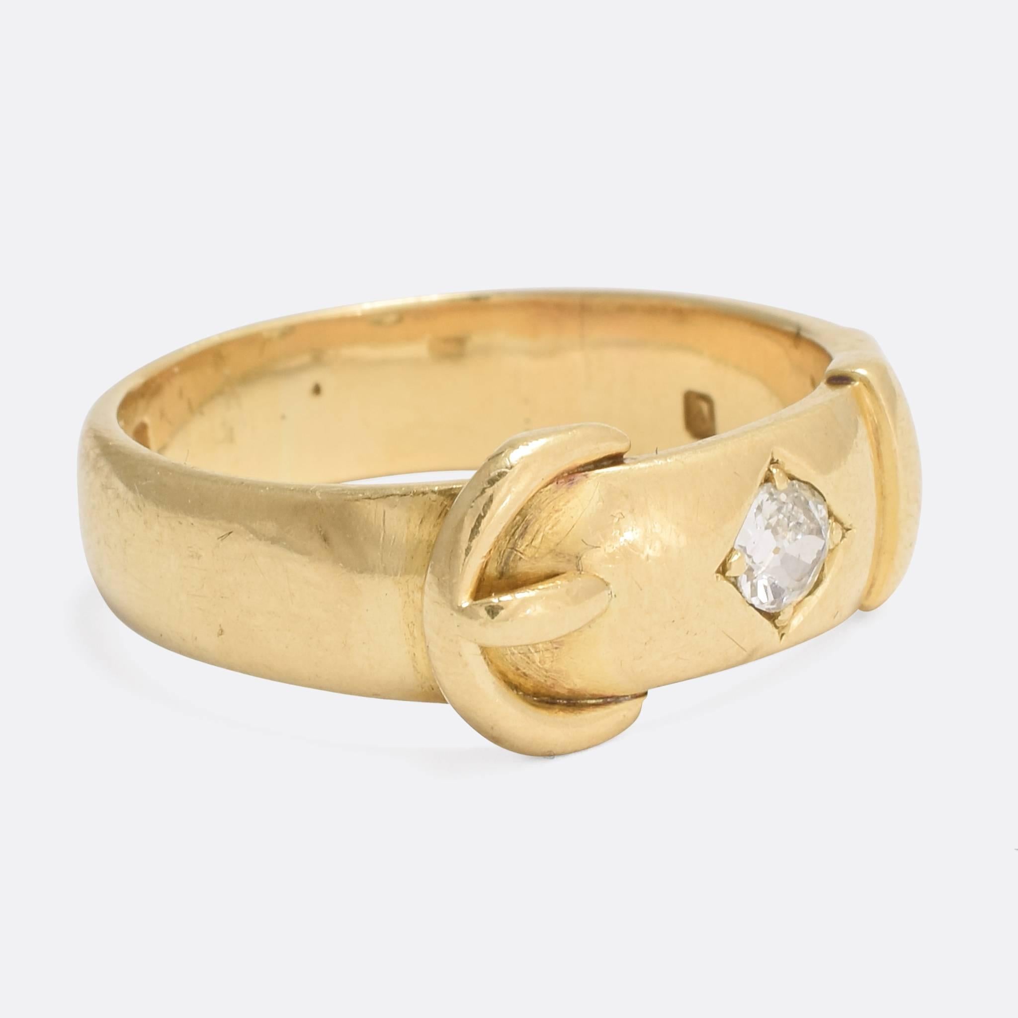 A classic antique buckle ring, set with two bright old mine cut diamonds. The buckle was popular in Victorian jewellery, representing a strong and eternal bond between two people. A substantial ring that displays beautiful craftsmanship, with clear