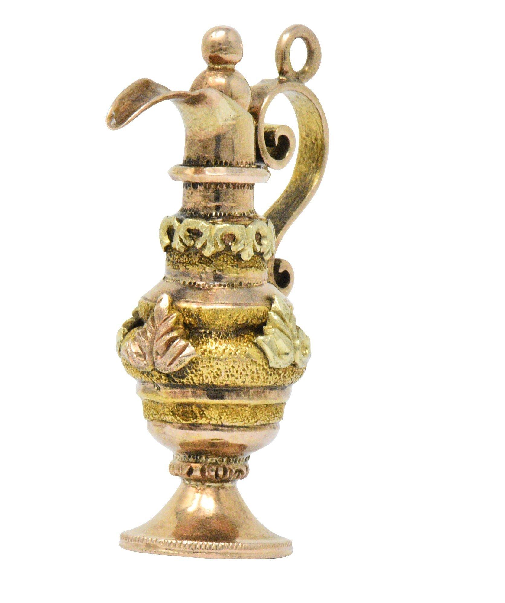 Designed as an ornate rose gold ewer with a scrolled handle and gold bead top

Decorated by applied rose and green gold leaves 

Accented by yellow gold banding with a highly stippled texture

Partial maker's mark

Circa: 1860s

Measuring approx.: