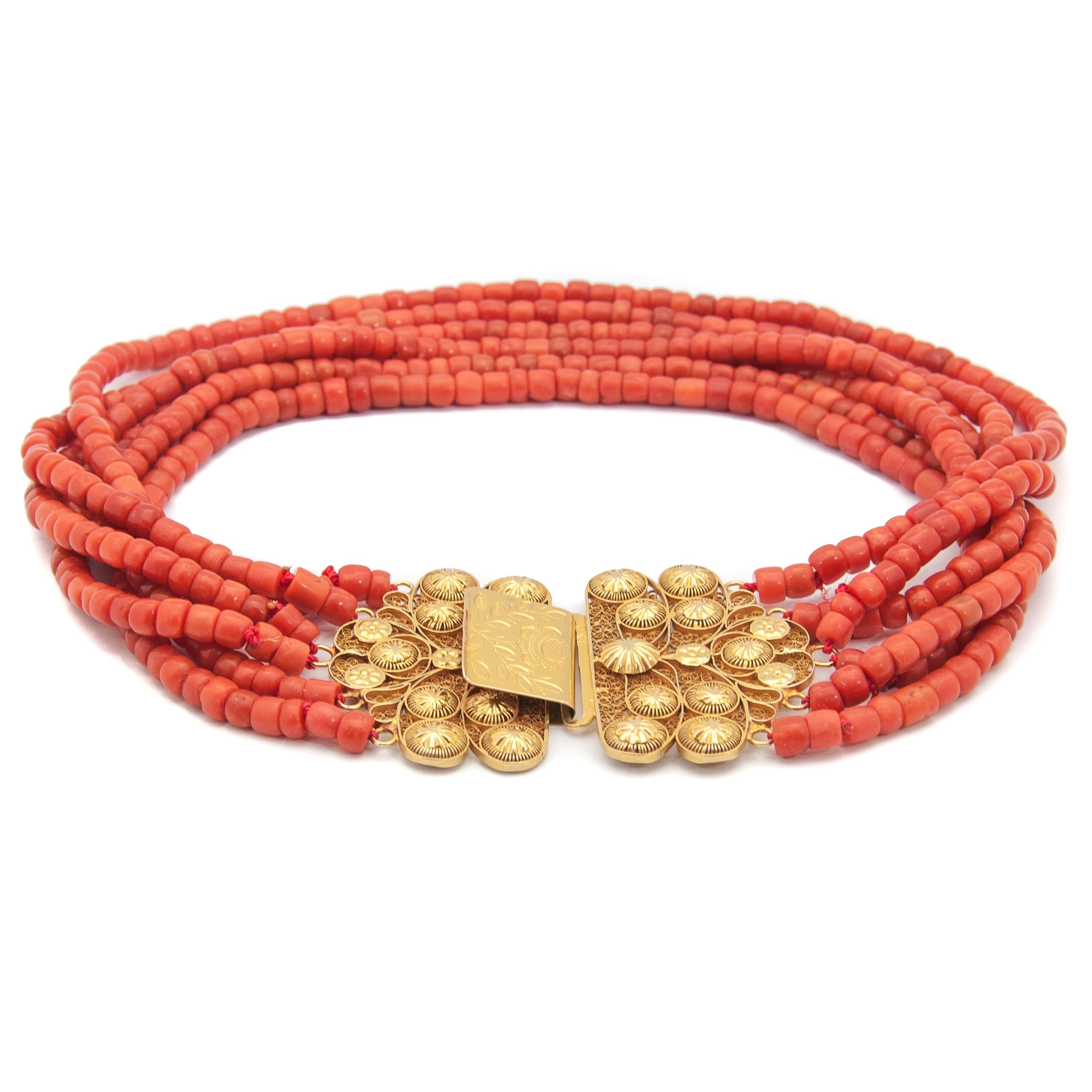 This antique 19th century coral necklace is set with a large 18 karat gold clasp. The clasp is made of fine filigree and cannetille work, the craftsmanship is stunning. The closure of the clasp has a lovely floral engraving. The six strands are