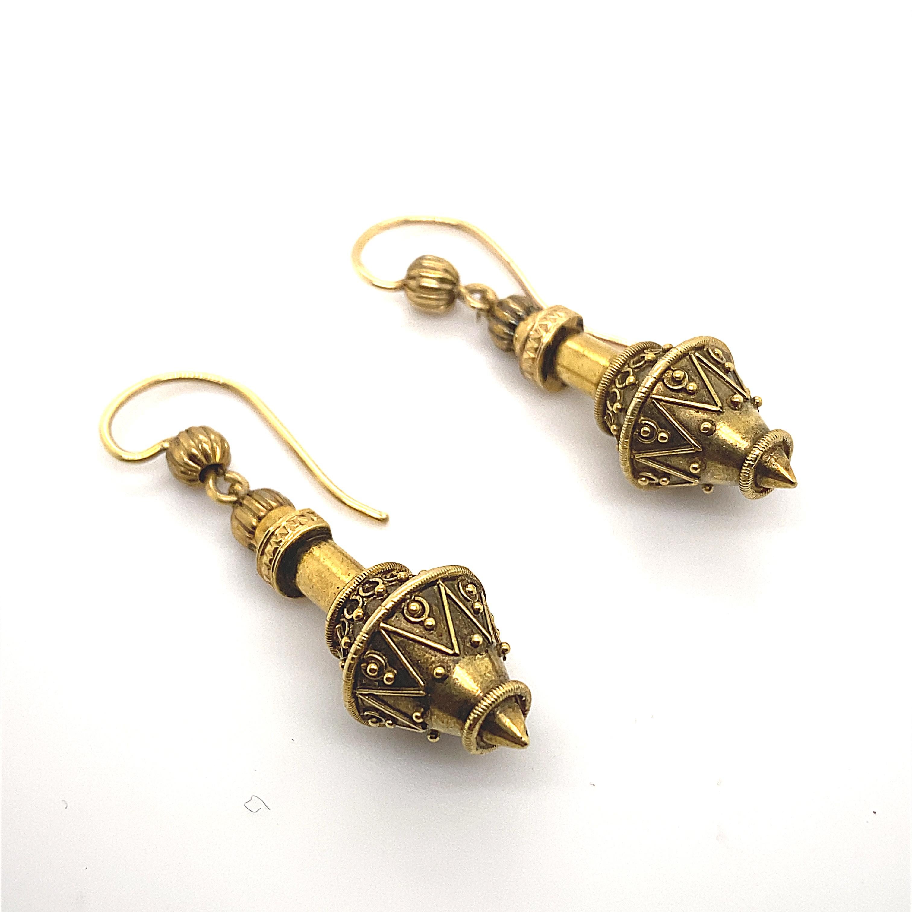 A pair of Victorian 18 karat yellow gold drop earrings.

Designed as rounded arrow shapes featuring fine granulation gold decoration throughout suspended from hook and wire fittings, and finished with open wirework designs.

These are crafted from