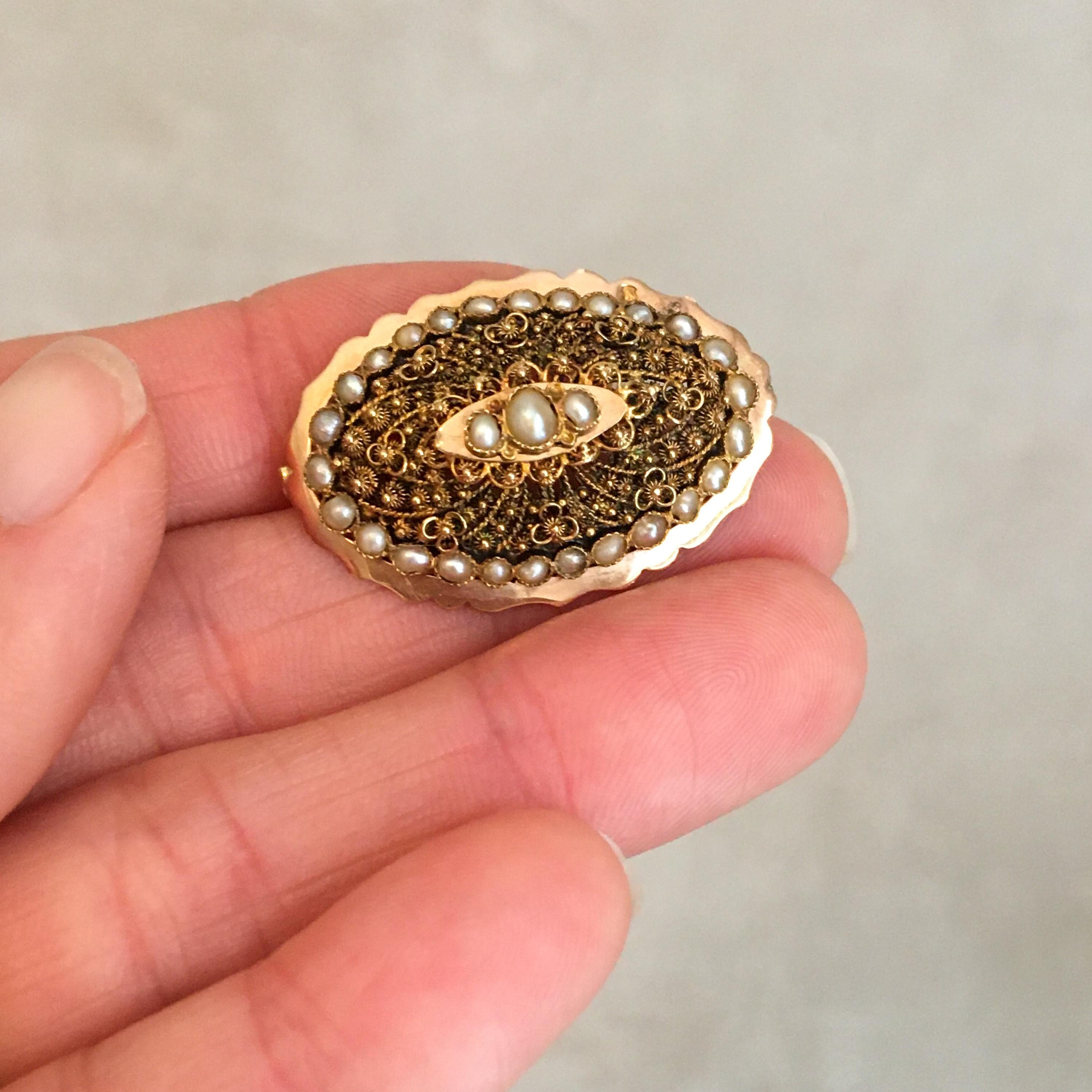This is an antique 19th Century 18 karat yellow gold brooch set with twenty-nine lustrous seed pearls. This beautiful brooch has very fine and detailed cannetille work while the border has a scalloped design. This kind of technique demands a very