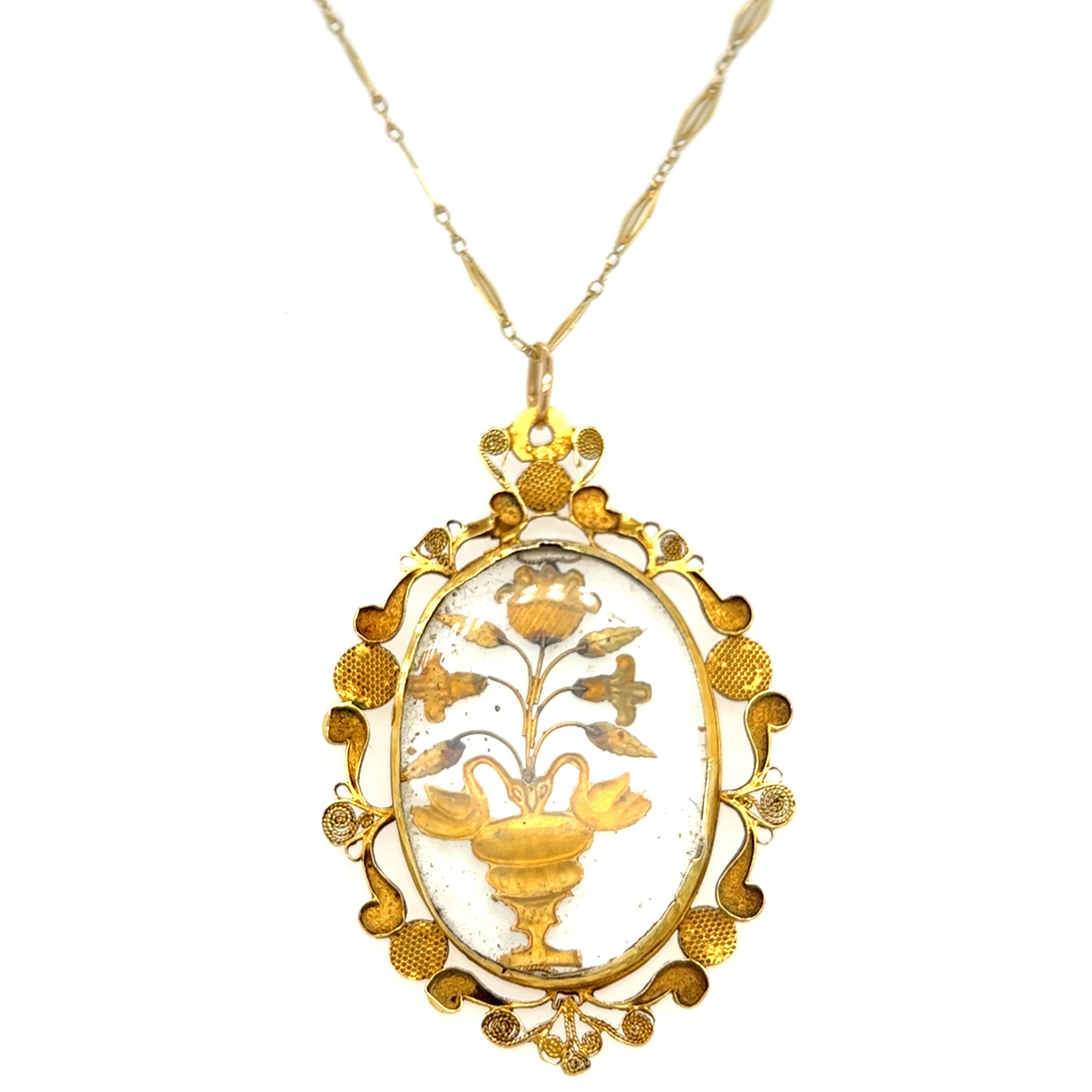 One 18 karat yellow gold oval Victorian locket style pendant necklace with transparent glass and 18 karat yellow gold floral design, assembled to a handmade 18 karat yellow gold chain measuring 18 inches long complete with a spring ring clasp. The