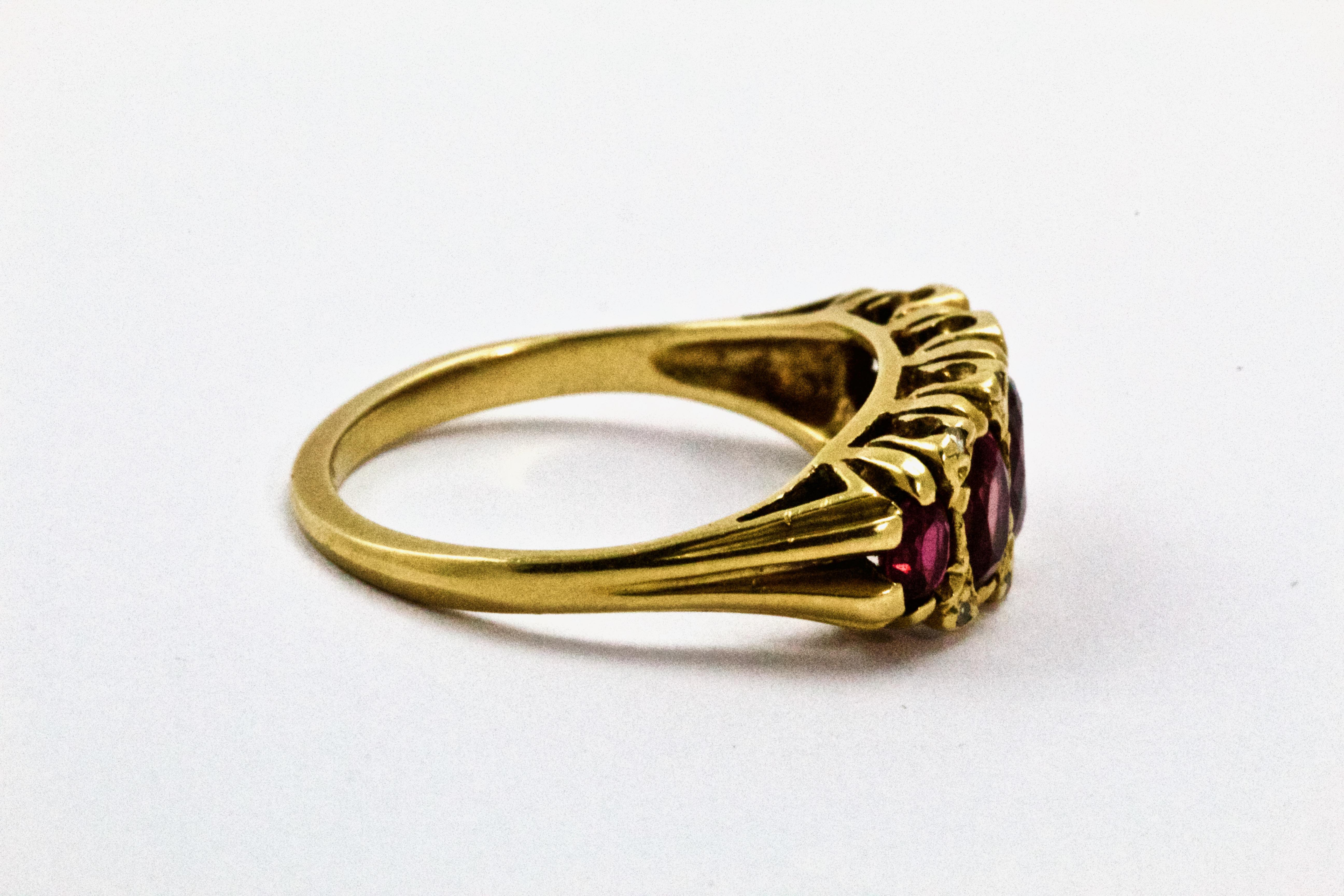 Cette époustouflante bague ancienne en rubis et diamants est de style victorien, vers 1880. La bague est ornée de cinq magnifiques rubis avec de jolies pointes de diamant taillées en rose. Le tout est serti dans une magnifique galerie victorienne en