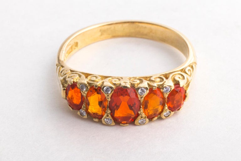 Ouch, you feel the fire of this five stone 18 Kt Victorian Fire Opal ring. It is as bright as lava freshly flowing from a volcano.There are tiny diamonds set between the opals. They give beautiful points of light. Fire opal is one of the rare