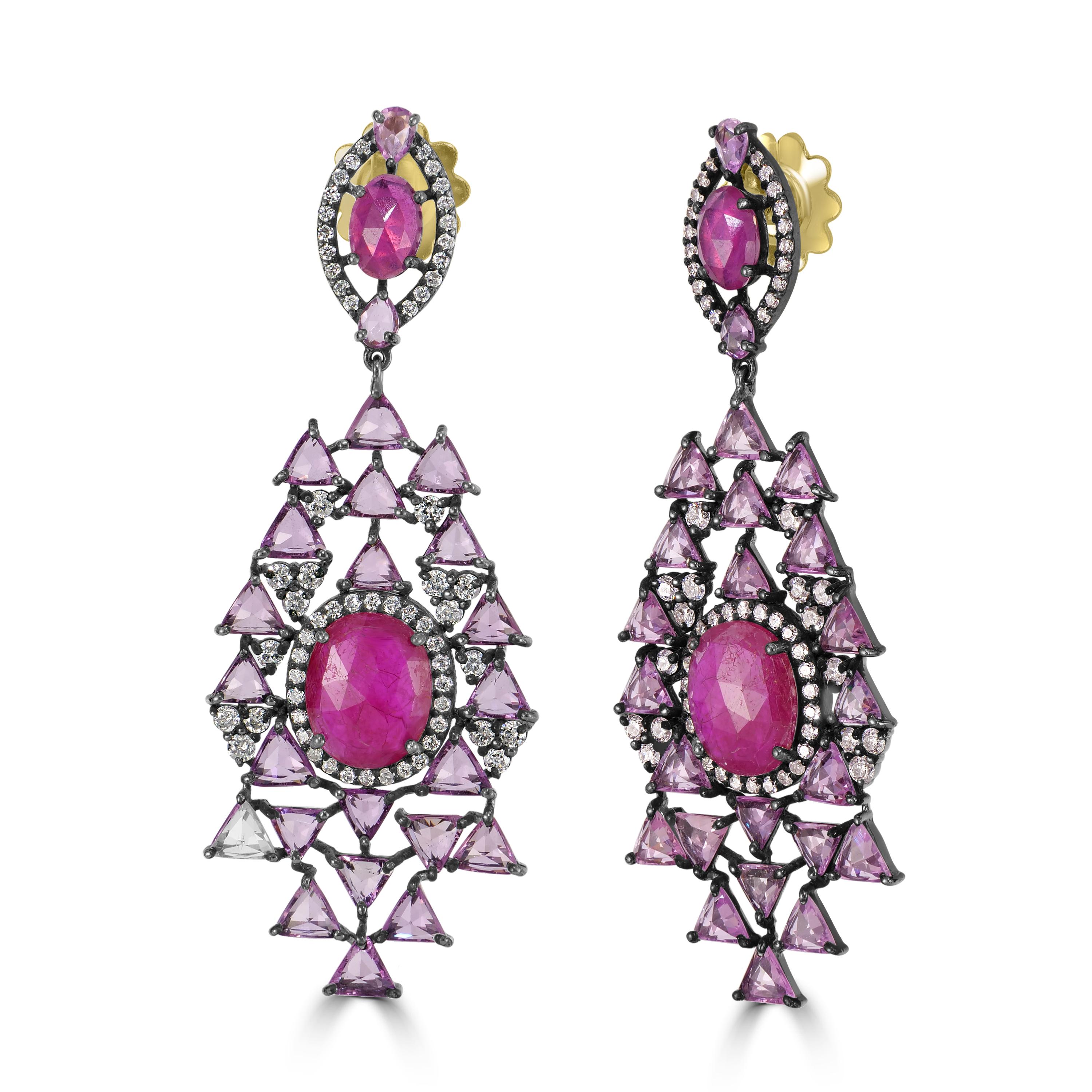 Wir stellen Ihnen unseren exquisiten viktorianischen 18,16 cttw. Ohrringe mit Rubin, rosa Saphir und Diamant, ein Meisterwerk von zeitloser Eleganz und Raffinesse.

Das Herzstück jedes Ohrrings ist ein faszinierender ovaler Rubin, der von einem Halo