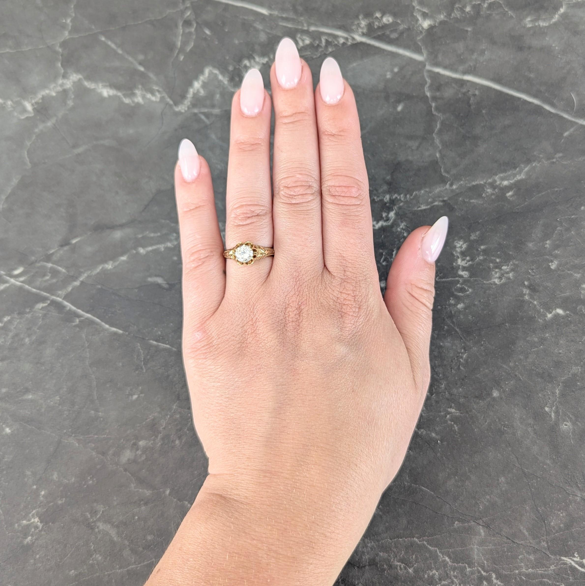 Centering an old European cut diamond weighing approximately 0.76 carat total - G color with VS1 clarity
Set with scalloped belcher style prongs forming a buttercup motif
Flanked by grooved shoulders with granulated detail
Accented by opaque black
