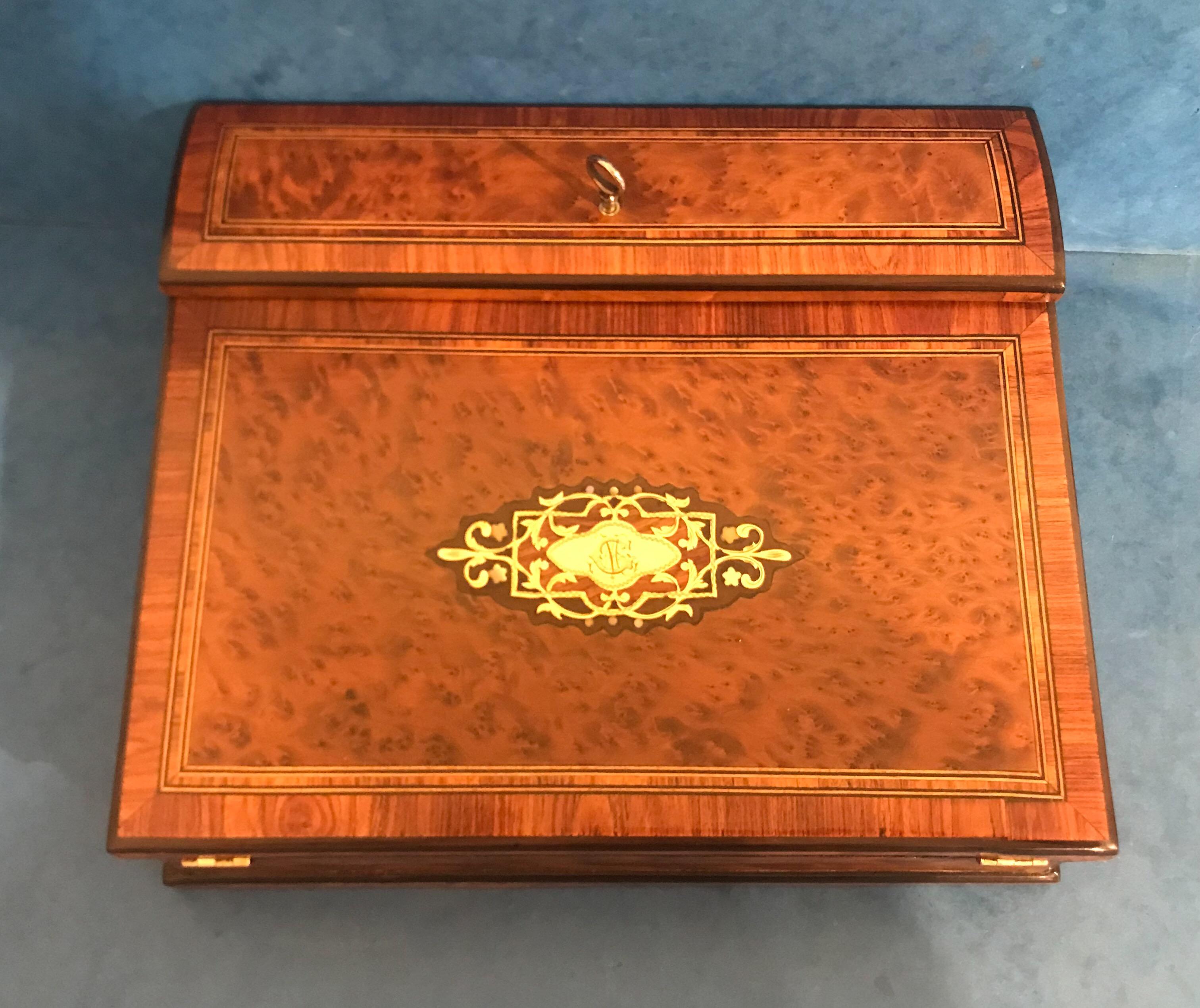 This is a very pretty French Victorian 1870 Burr cedar brass inlaid tulip wood cross banded ladies lap desk, it has a rosewood interior, its original velvet writing surface ,original silver plated ink wells and original working lock and original