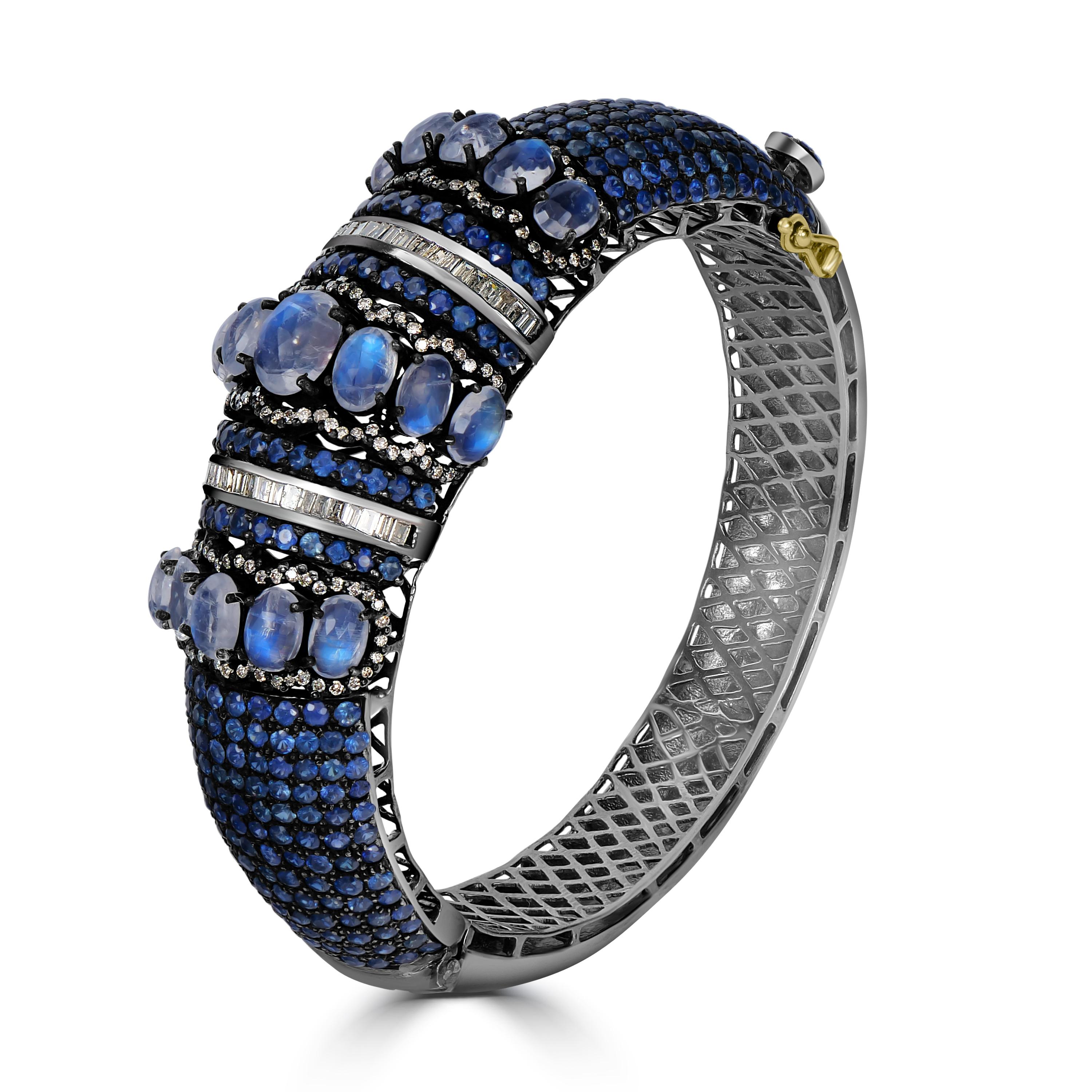 Introducing our Victorian 18.9 Cttw. Rainbow Moonstone, Blue Sapphire, and Diamond Bangle, a true testament to Victorian-era elegance and opulence.

This exquisite Victorion bangle boasts a stunning combination of gemstones, meticulously arranged to