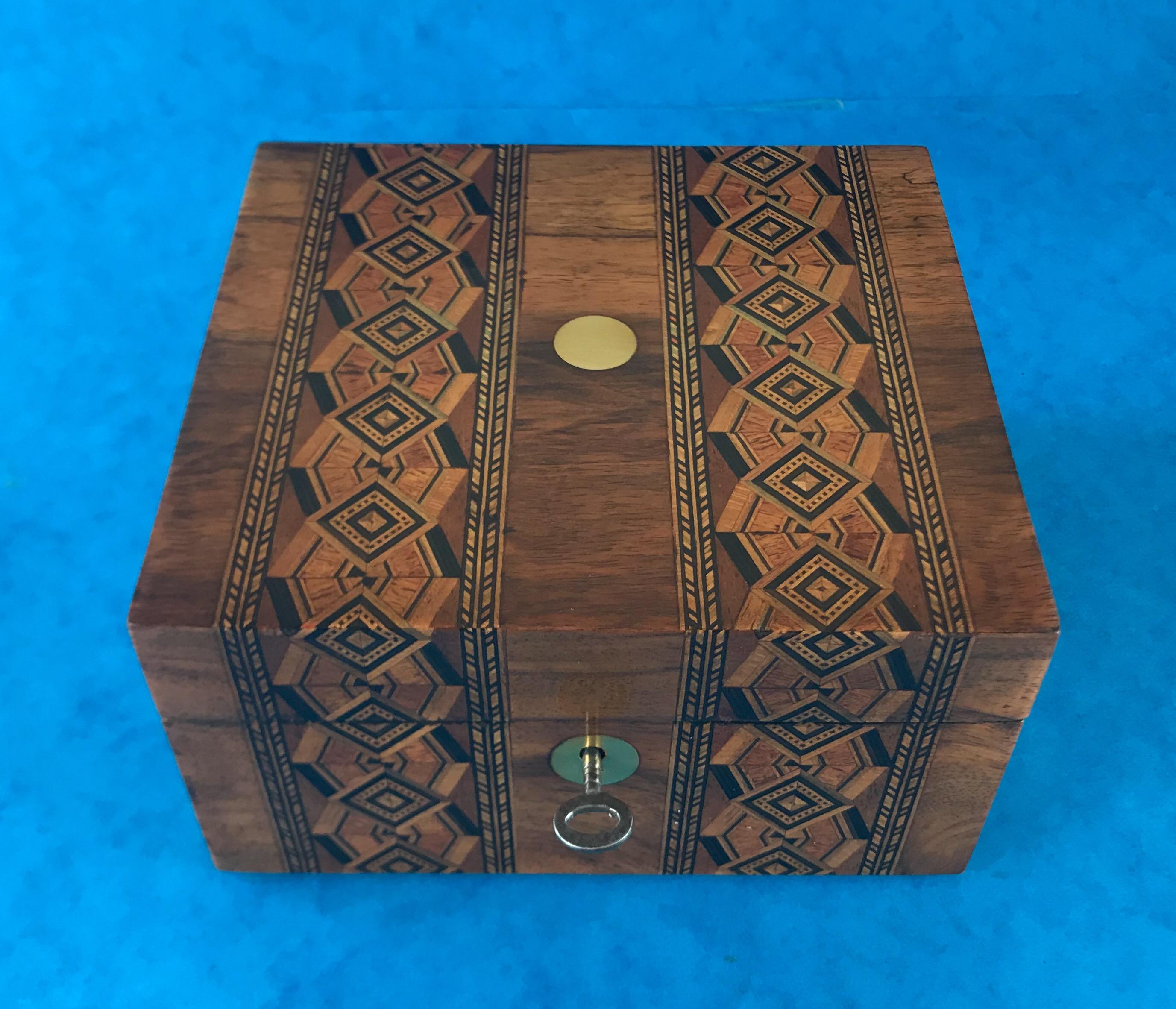 A Victorian 1890-1900 inlaid walnut tunbridge ware box, it has its original silk and paper interior and a working lock and key, it’s in beautiful condition and measures 17 by 16 and stands 9.5 cm high.
 