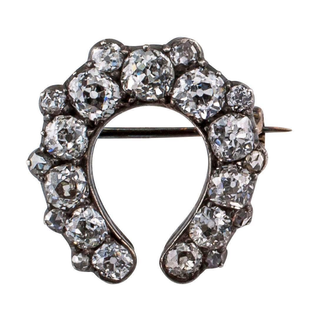 Victorian 1890s horseshoe diamond brooch. The design features twenty-one old mine-cut diamonds totaling approximately 2.30 carats, mounted in silver over 15-karat gold. Very bright and sparkly old mine-cut diamonds, excellent condition consistent
