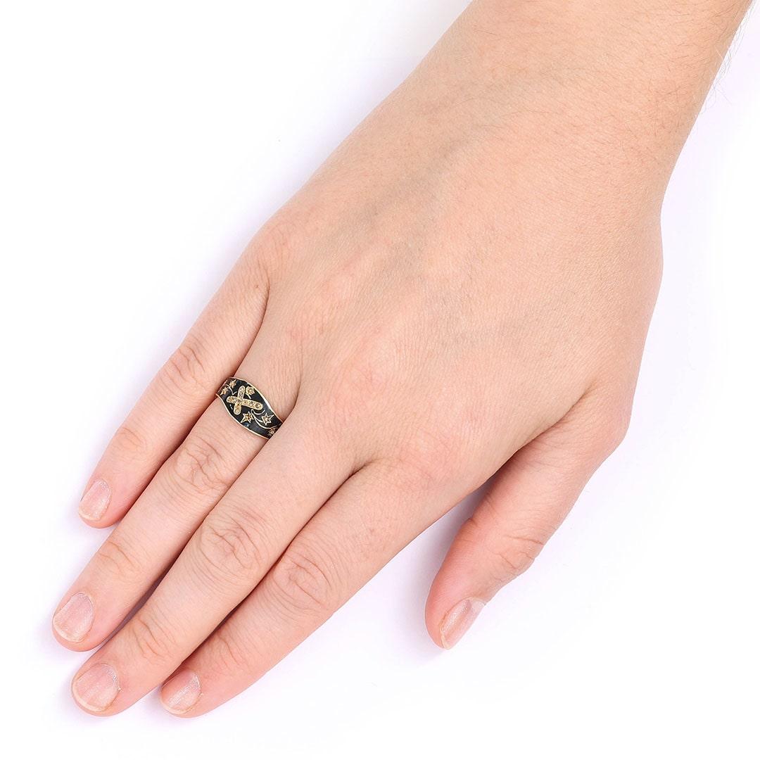 A pretty and unique victorian 18ct gold diamond cross and black enamel mourning ring, crafted in England circa 1870. The outer black enamel band, encompassing the design consisting of a central diamond set cross, conveying plenty of religious