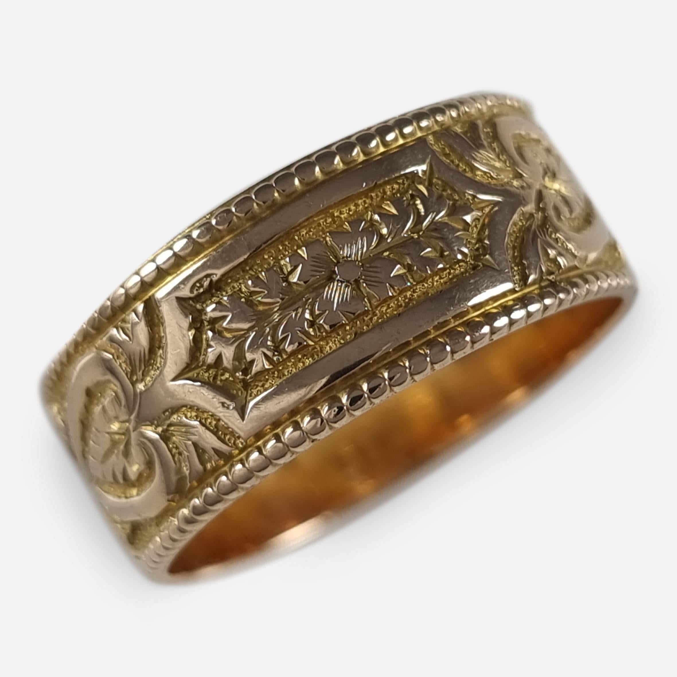 A Victorian 18ct yellow gold engraved Keeper ring. The ring is engraved with an embossed foliate decoration.

The ring is hallmarked with Birmingham marks, '18' for 18 carat gold, and date letter 'i' to denote 1883.

Assay: - .750 Gold