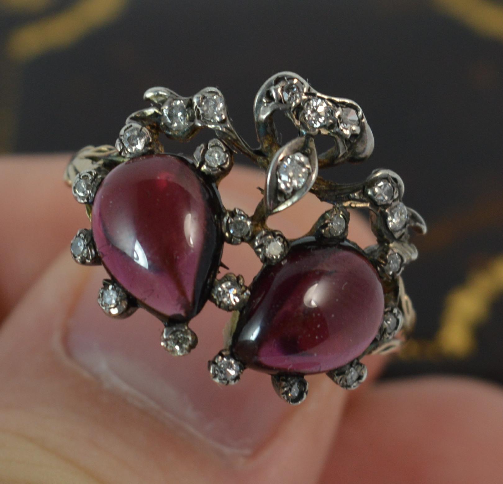 A stunning quality double heart design cluster ring.
SIZE ; Q UK, 8 US
Mid to late Victorian period piece, c1860.

Designed with two pear shaped garnet cabochon stones with natural old cut diamonds surrounding.

Fine yellow gold patterned