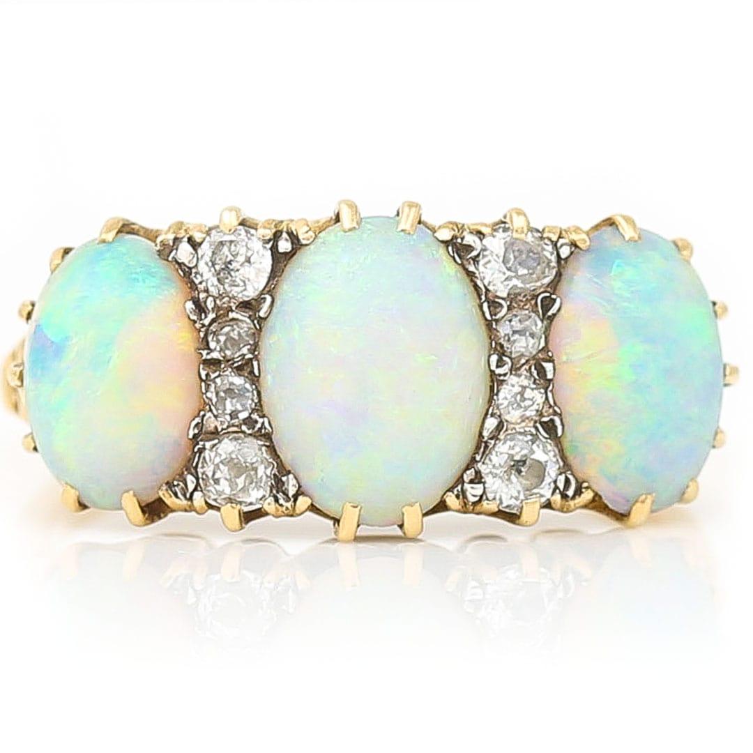 An impressive Victorian 18ct yellow gold, opal and diamond three stone gypsy ring. All the gemstones are claw set with the opals displaying superb ‘fire’ showing predominantly electric blue, flashes of green and the rarer orangey-red. The sparkling