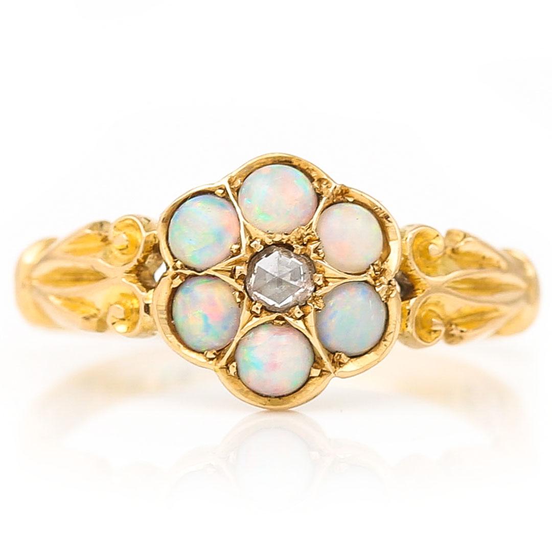 A very pretty Victorian 18ct yellow gold precious opal and rose cut diamond seven stone cluster ring dating from circa 1900. The delightful ring now will into its 120th year has a central set rose cut diamond around which seven precious opals sit
