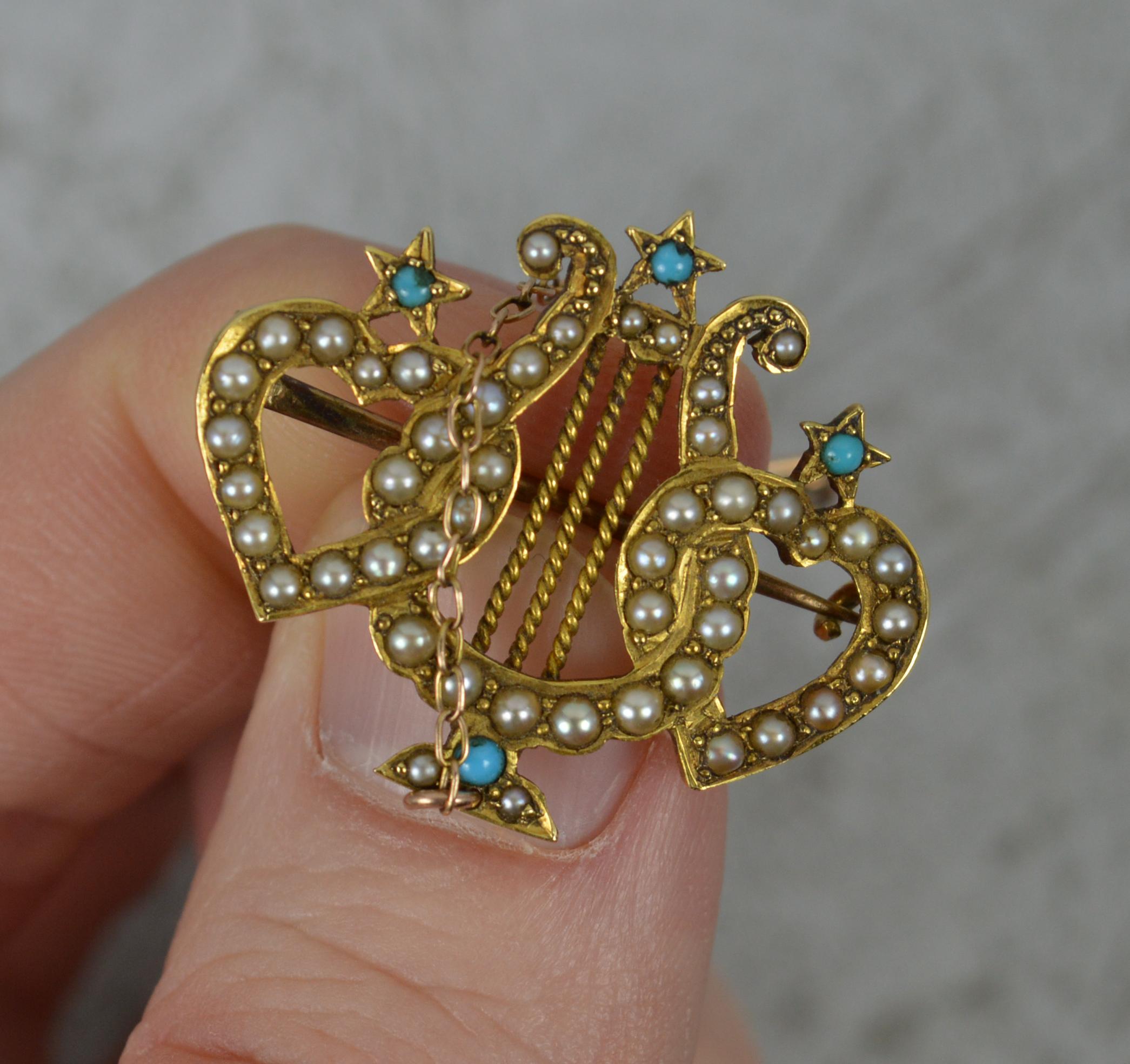 A true mid to late Victorian era brooch. c1880.
Solid 18 carat yellow gold example.
Designed with a musical lyre to centre with two entwined hearts, one set to each side. 
All encrusted with seed pearls and turquoise stones.

CONDITION ; Very good