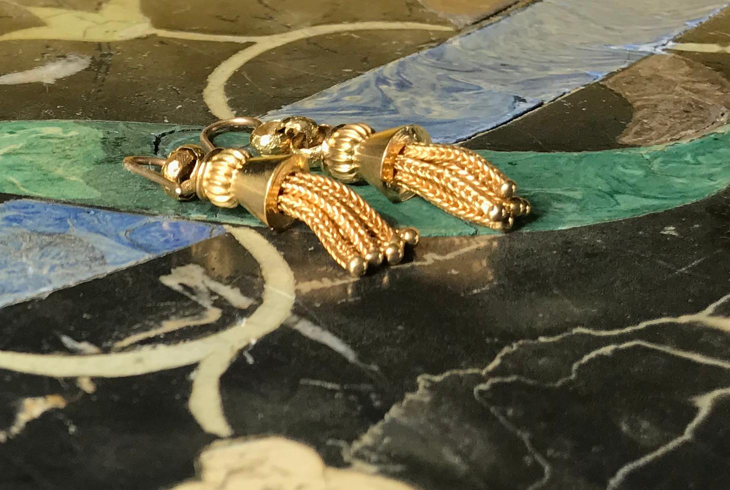 A stunning pair of 18K Victorian drop earrings with shimmering tassels with movement and flair. The braided tassels are punctuated with a decorative gold ball at the end of each, giving the tassels a bit of weight which helps create a sense of