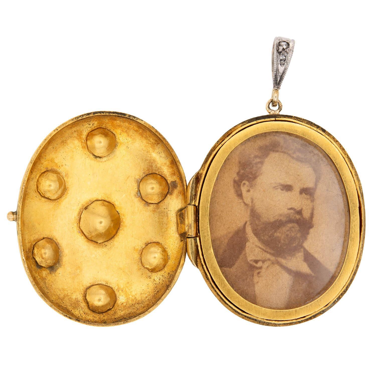 ¡Un relicario fenomenal de la época victoriana (ca1880s)! Elaborado en oro amarillo de 18 quilates, la superficie frontal del medallón ovalado está adornada con un profundo esmalte negro. La parte frontal del medallón también está decorada con siete