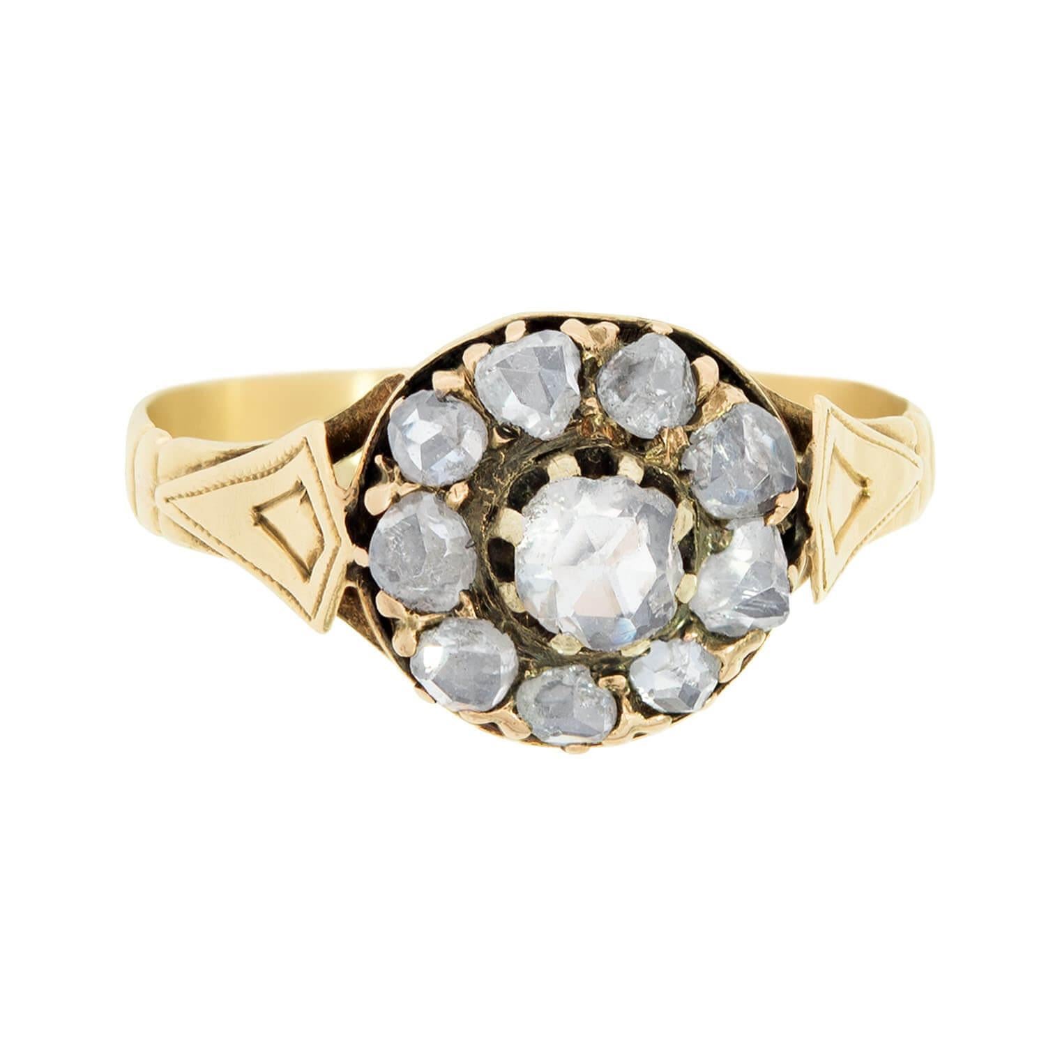 An exquisite diamond halo ring from the Victorian era (ca1880)! This gorgeous ring is crafted in 18k yellow gold, and features an elegant diamond encrusted design. The centerpiece of the ring features a flower motif, which is represented by 10 rose