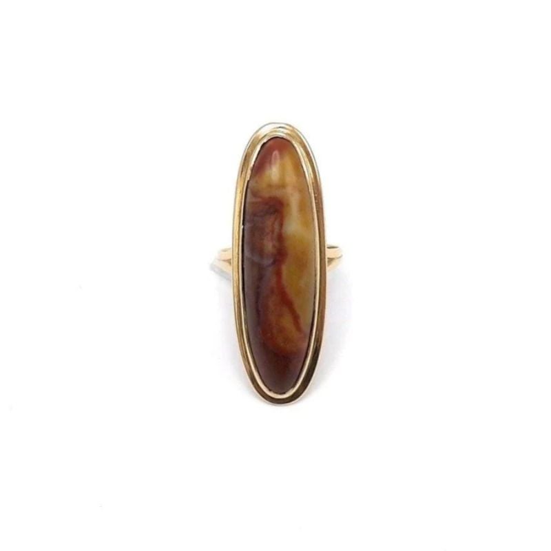 This stunning 18k gold and agate cabochon ring is from the Victorian era. The striking bezel set agate is an elongated oval shape, which graces the hand elegantly. The agate contains a marbled array of beautiful earth tones ranging in color from