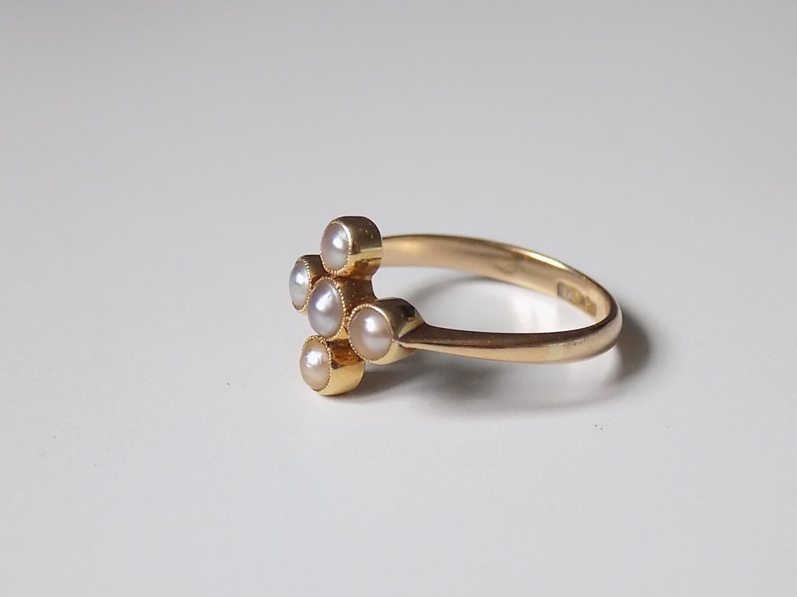 A Lovely Victorian c.1880 18 Carat Gold and split Pearl cross style ring. The pearls slight grey colour in closed back setting. English origin.
Size M UK, 6.5 US.
Height of the face 11mm.
Weight 2.5gr.
Marked for 18 Carat Gold.