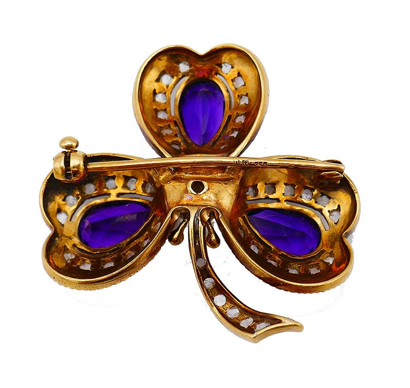 Antique clover pin made of 18 karat yellow gold, enamel, amethyst and accented with a pearl and rose cut diamonds. The amethysts are pear cut, approximately 8.50 carats total weight.
Measurements: 1 ½” x 1 ½” (4 x 4 cm).
Weight: 16.7 grams.
Stamped